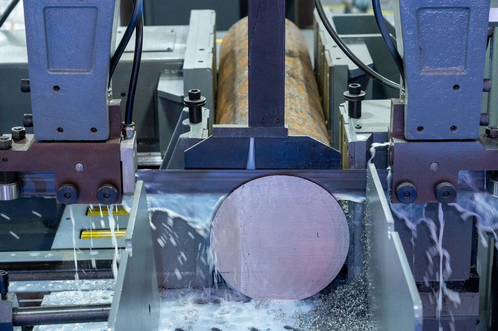 Close-up of an industrial machine cutting a metal rod with precision. Stock photo illustrating Uniparts India's earning call story.