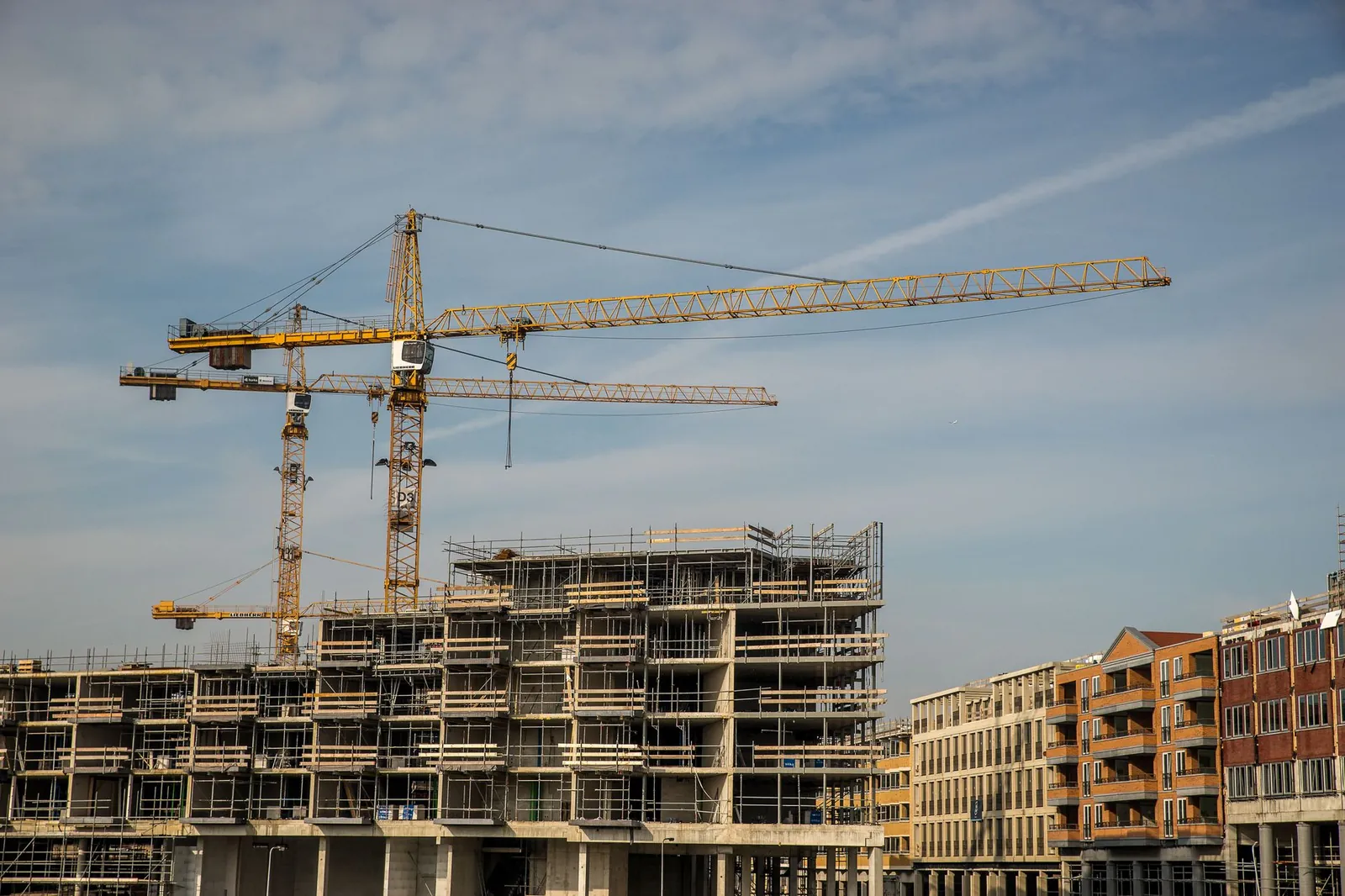 City construction site with cranes and partially built structures under a clear sky. Stock photo illustrating Embassy Developments' new order story.