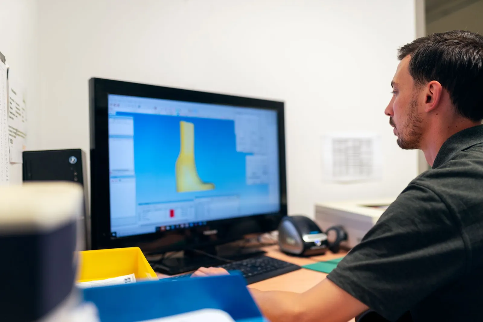 Engineer working on prosthetic design using specialized software in an office setting. Stock photo illustrating Tata Technologies' earning call story.
