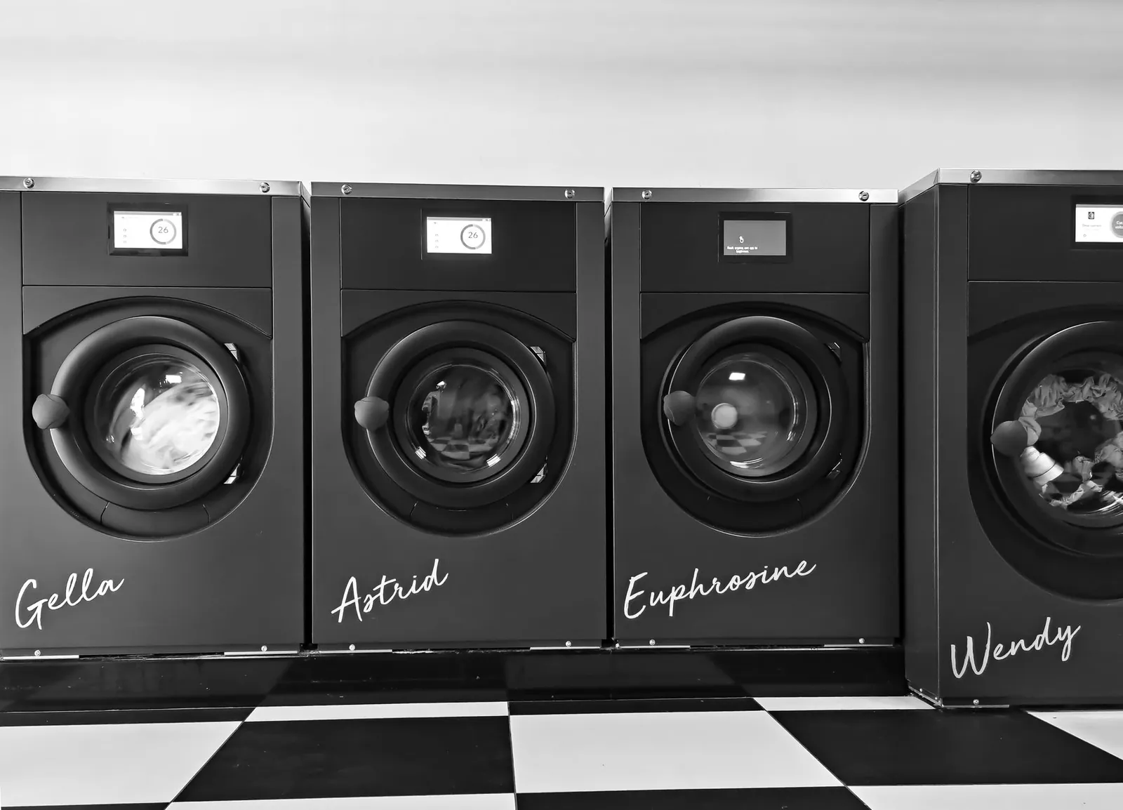 Grayscale image of four modern washing machines in a self-service laundry. Stock photo illustrating LG Electronics India's product launched story.
