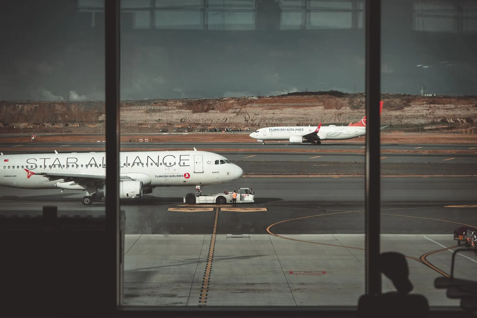 A view through airport windows showing airliners on the runway, creating a travel ambiance. Stock photo illustrating Coforge's product launched story.