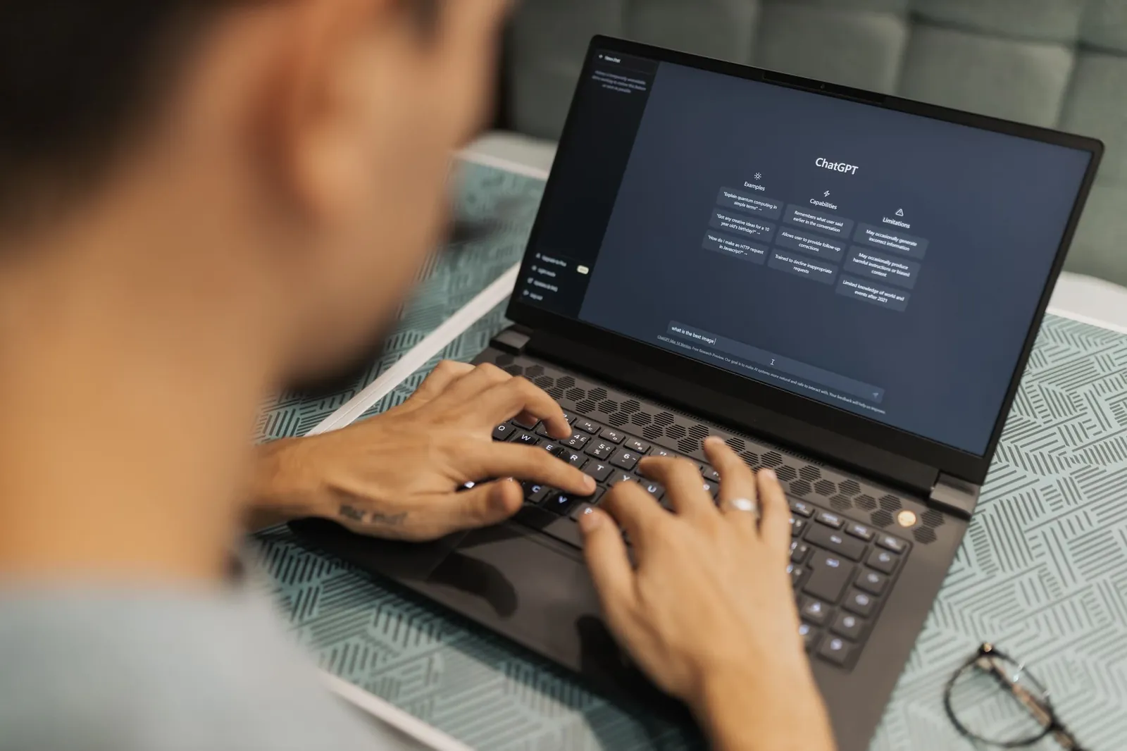 A focused individual types on a laptop running AI software indoors. Stock photo illustrating Coforge's product launched story.