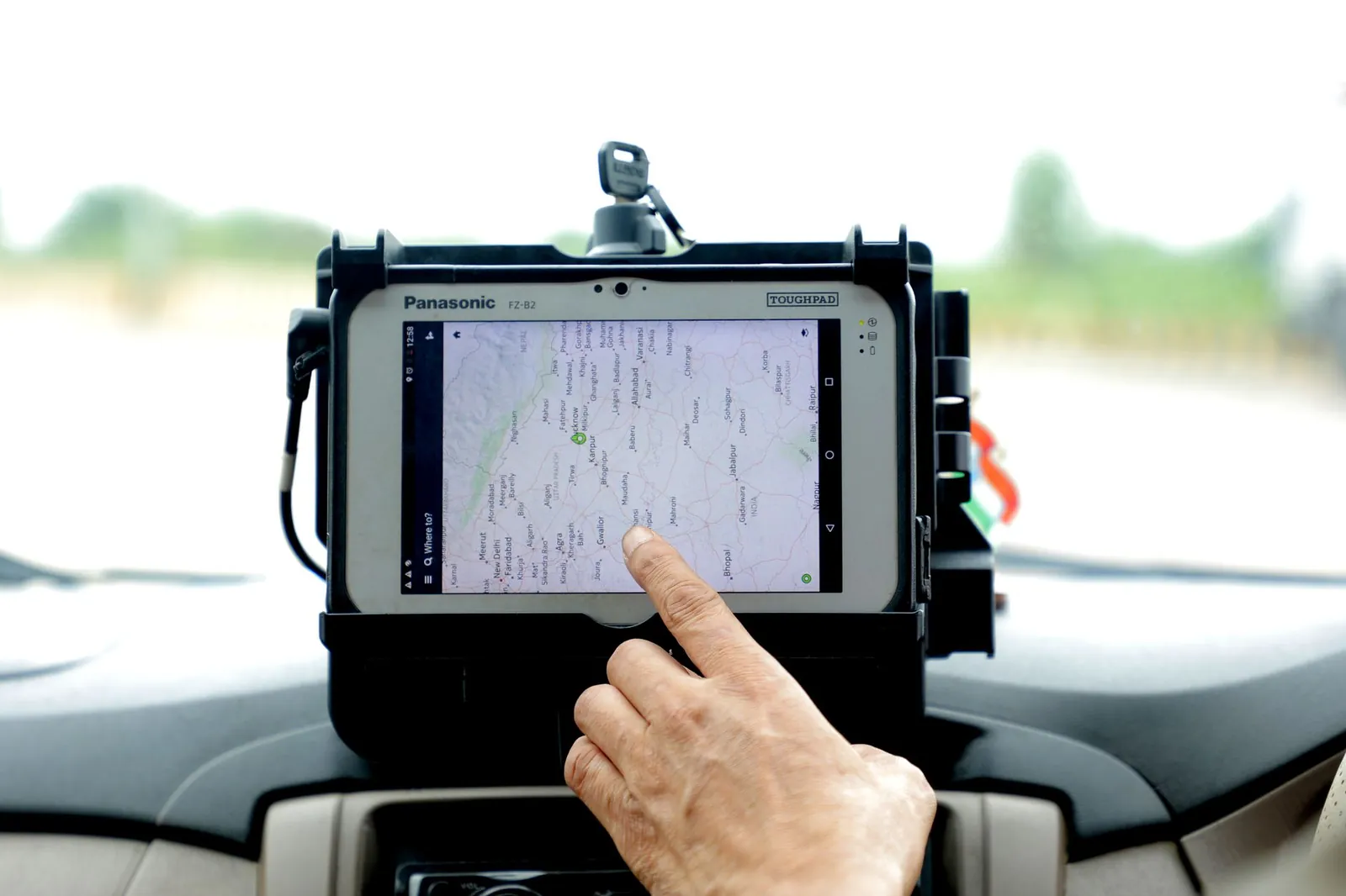 Close-up of hand interacting with GPS navigation on a car-mounted tablet screen, showcasing modern technology. Stock photo illustrating Ceinsys Tech's earning call story.