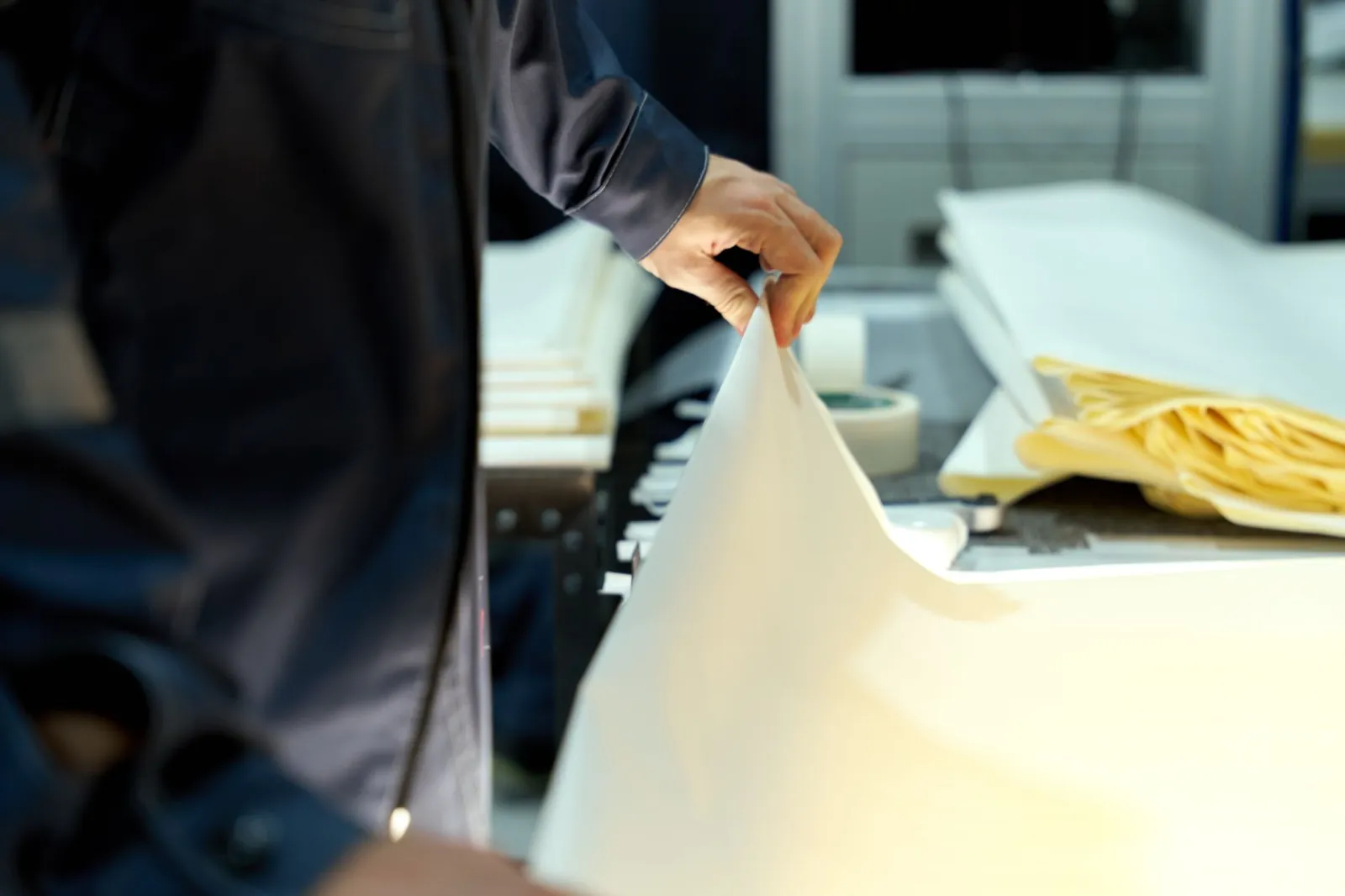 An industrial worker manages large sheets in a manufacturing setting, focusing on precision and quality. Stock photo illustrating Rushil Decor's production started story.