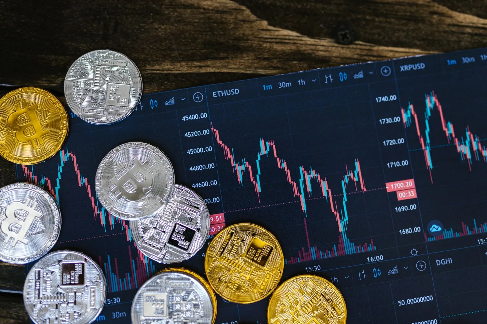 Close-up of gold and silver cryptocurrency coins on a digital trading chart. Stock photo illustrating Paul Merchants' product launched story.