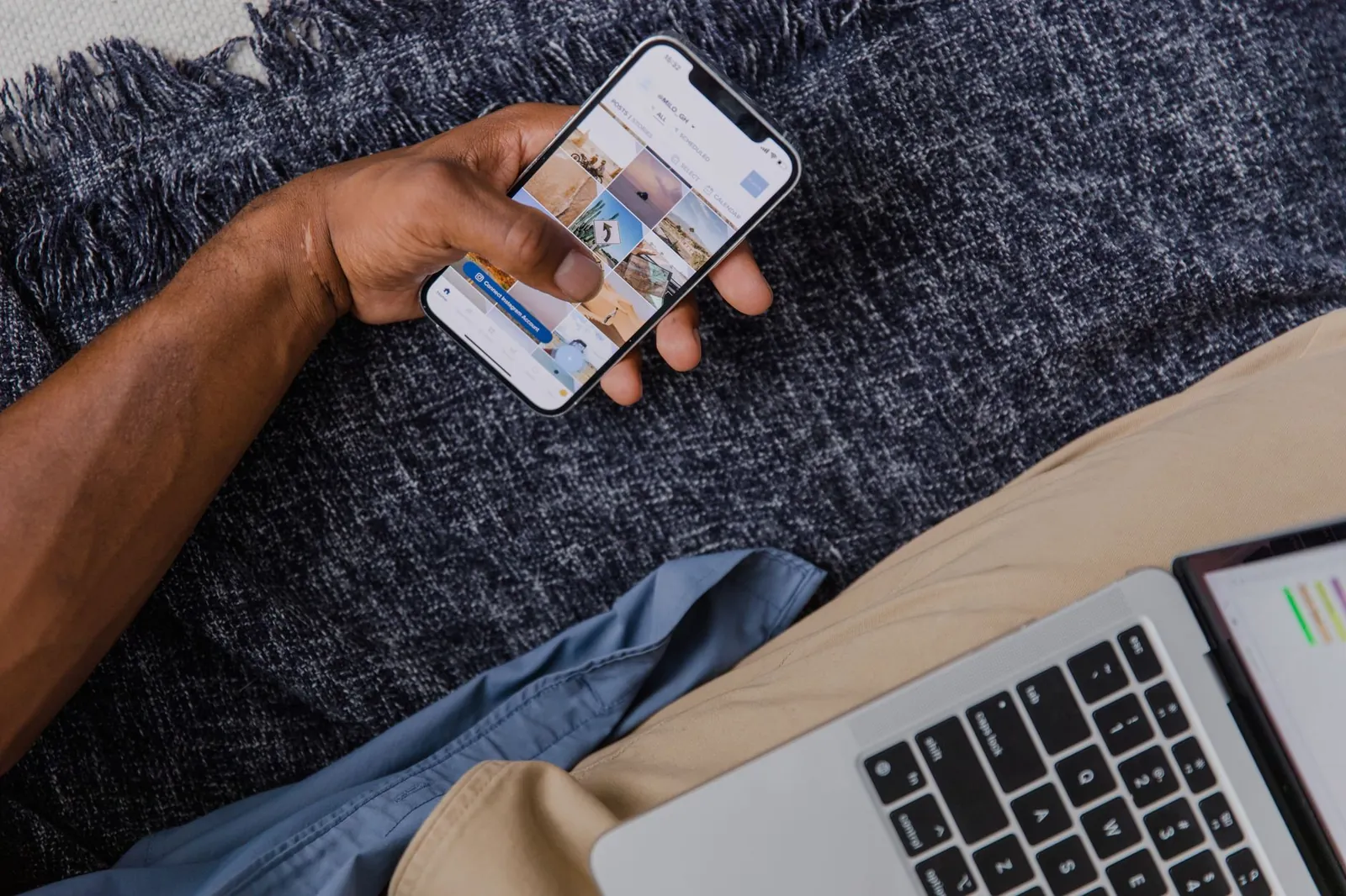 Hand holding smartphone with open laptop, showcasing modern digital lifestyle. Stock photo illustrating ICICI Lombard General Insurance Company's product launched story.