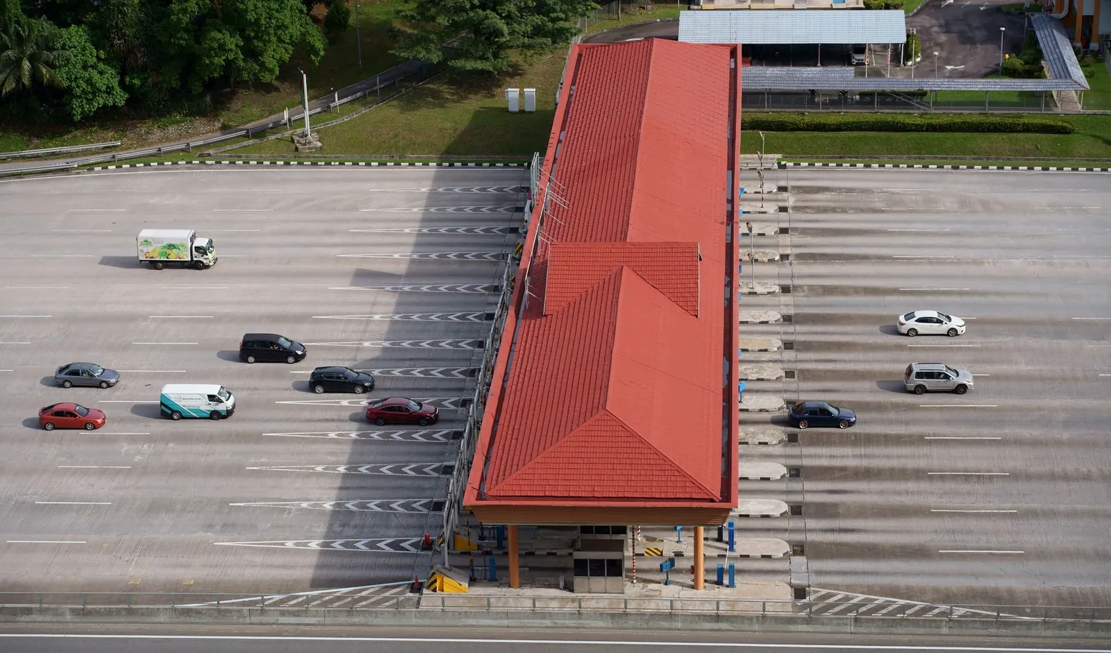High angle aerial shot of a toll plaza with cars and trucks on an expansive highway. Stock photo illustrating Highway Infrastructure's new order story.