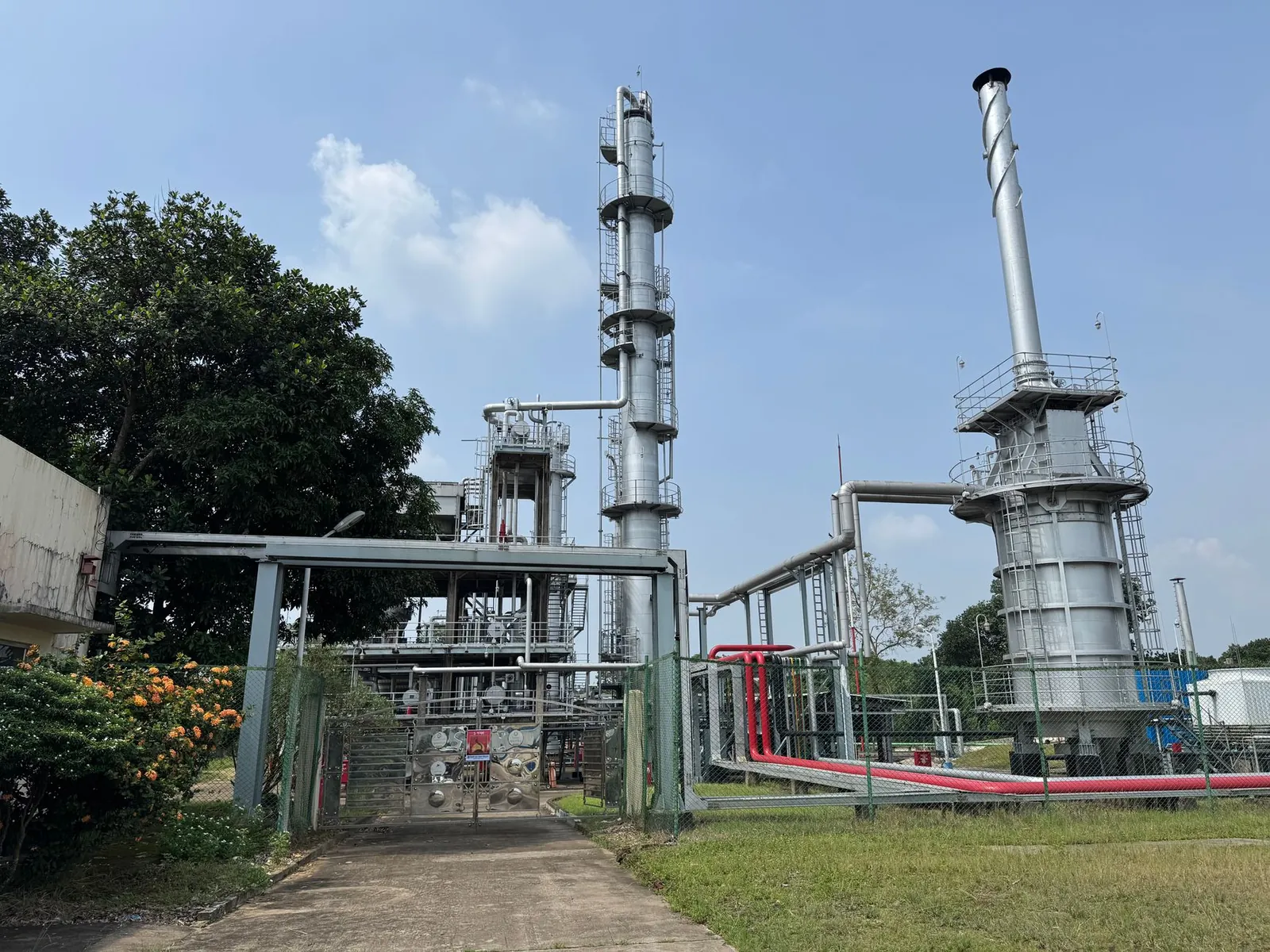 A large industrial plant outdoors with metal structures and clear blue sky. Stock photo illustrating Dhariwalcorp's fund raise story.