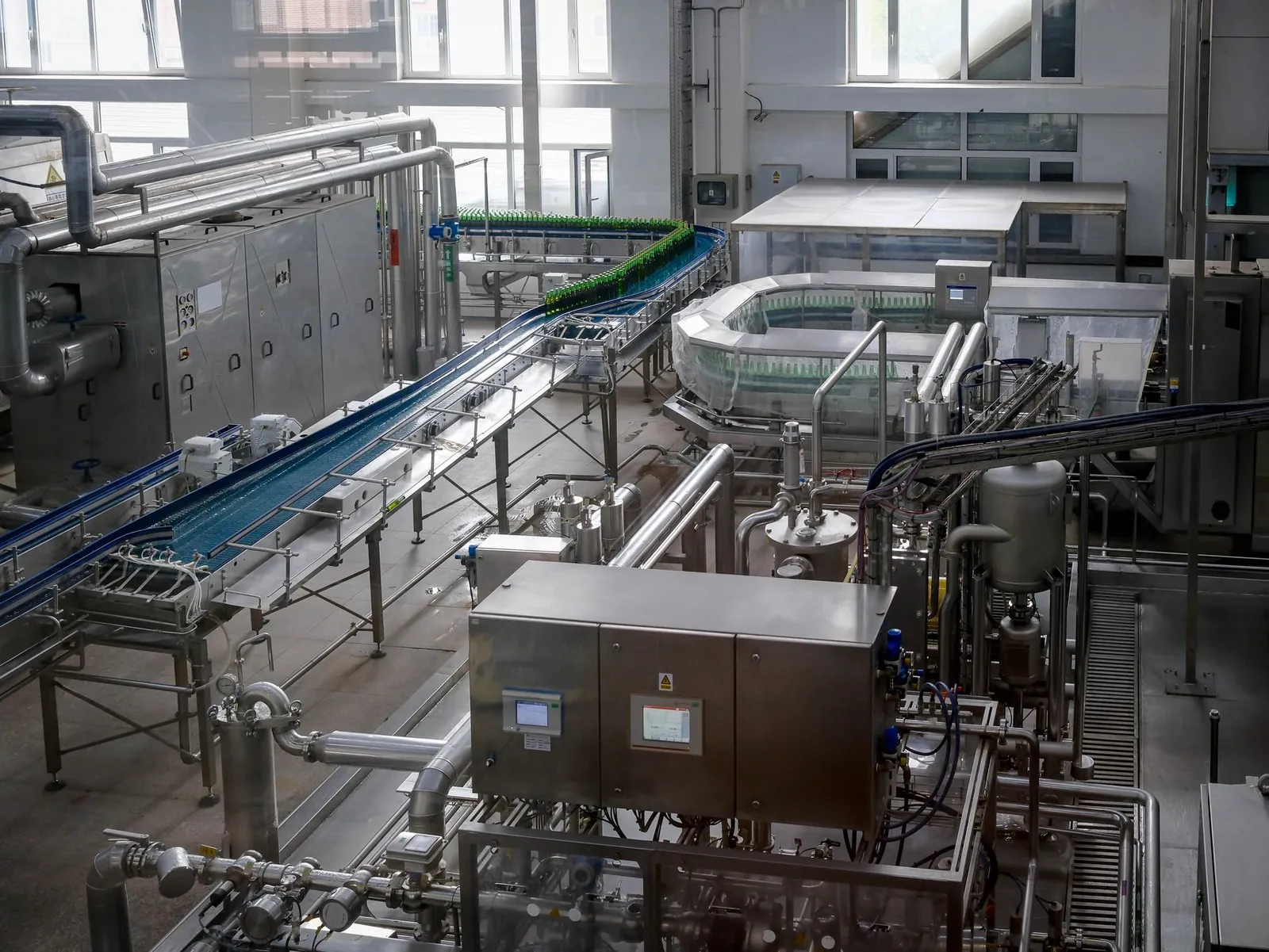 Interior view of an automated beverage bottling factory with machinery and conveyor belts. Stock photo illustrating Kwality Pharmaceuticals' earning call story.