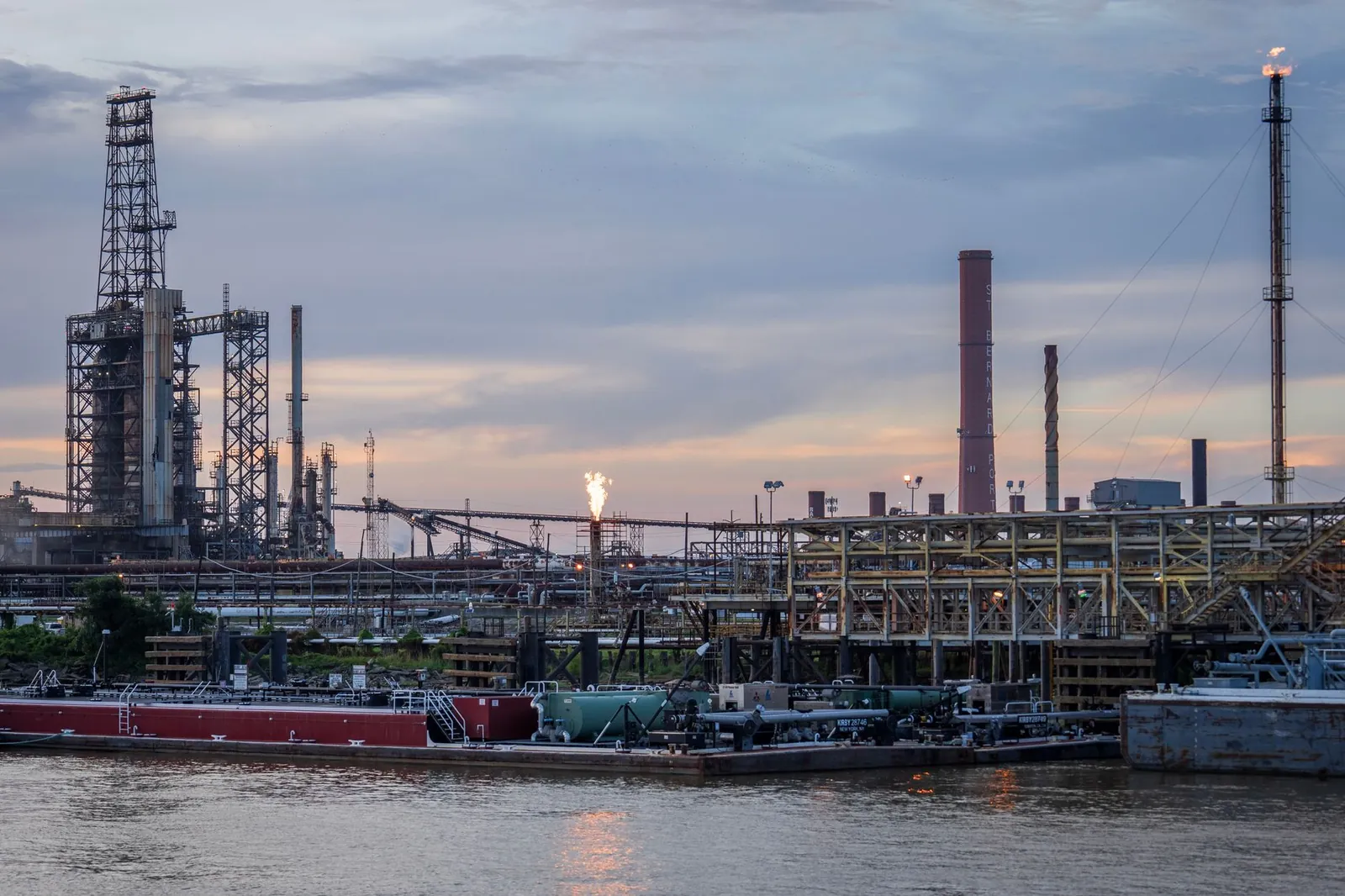 A large industrial refinery complex next to a river with a sunset backdrop. Stock photo illustrating Engineers India's new order story.