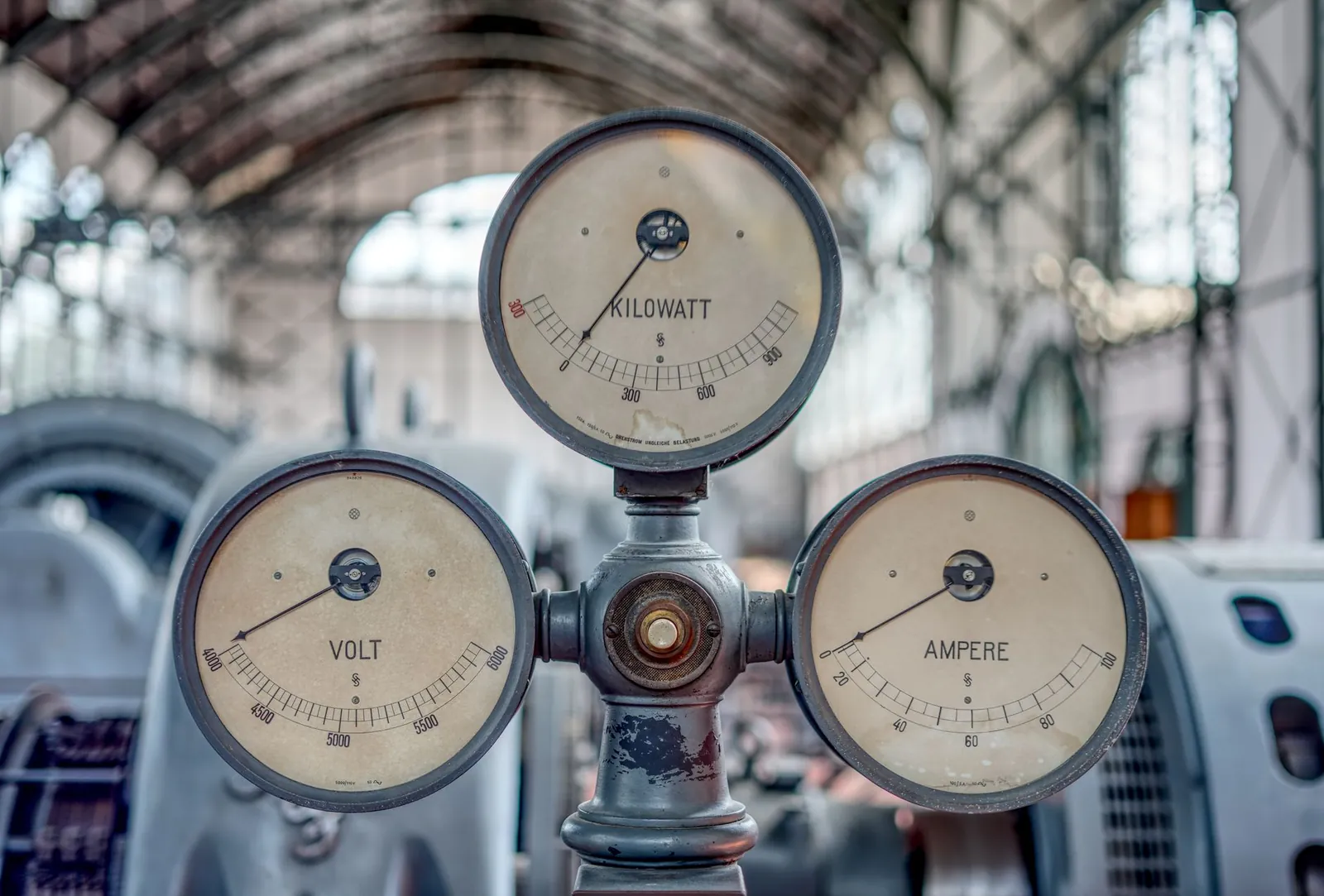 Close-up of vintage volt, ampere, and kilowatt gauges in an old industrial setting. Stock photo illustrating Bharat Bijlee's financial results story.