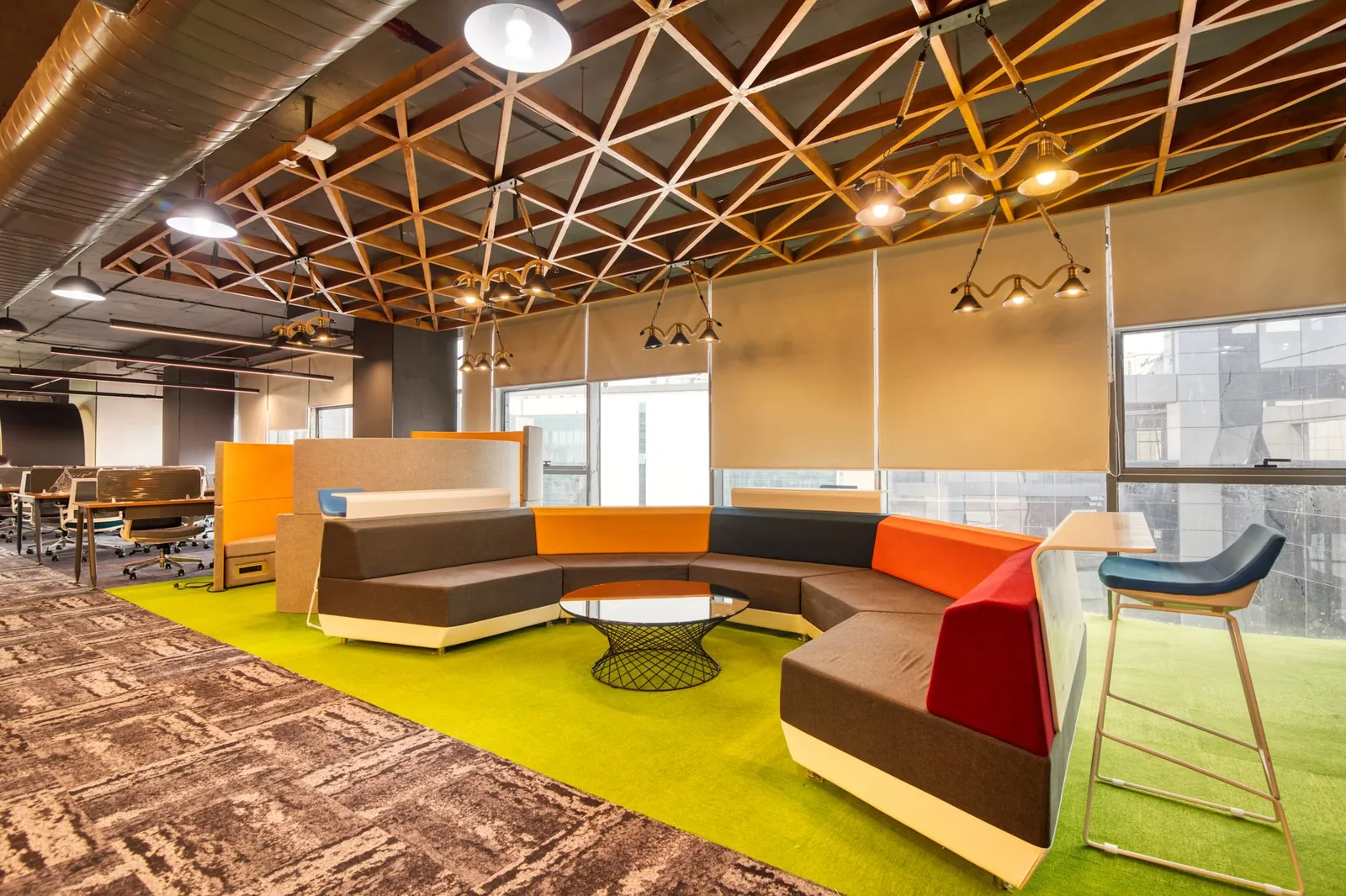 Vibrant open office space with colorful seating and contemporary design elements. Stock photo illustrating Smartworks Coworking Spaces' financial results story.