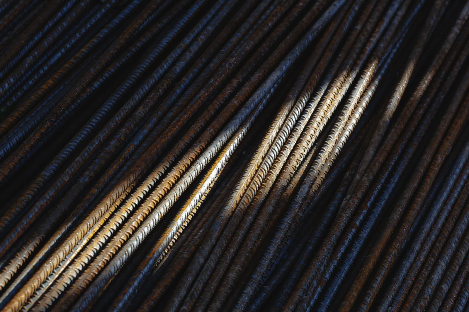 Artistic close-up of rusty steel rebars with dramatic lighting and texture. Stock photo illustrating Steel Exchange India's regulatory approval story.