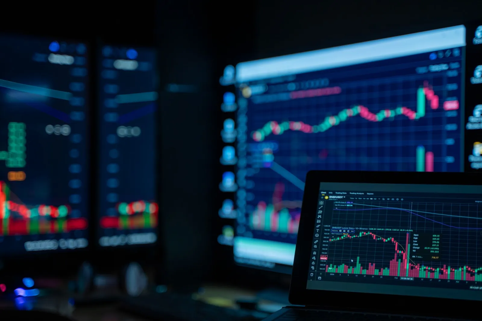 Monitors displaying stock market charts in a dimly lit room, perfect for finance and trading themes. Stock photo for the ALFA News guide: Understanding Corporate Announcements on the NSE and BSE.