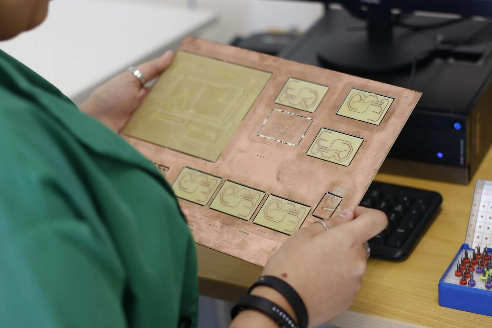 A technician examines a printed circuit board in a modern electronics lab. Stock photo illustrating Virtuoso Optoelectronics' fund raise story.