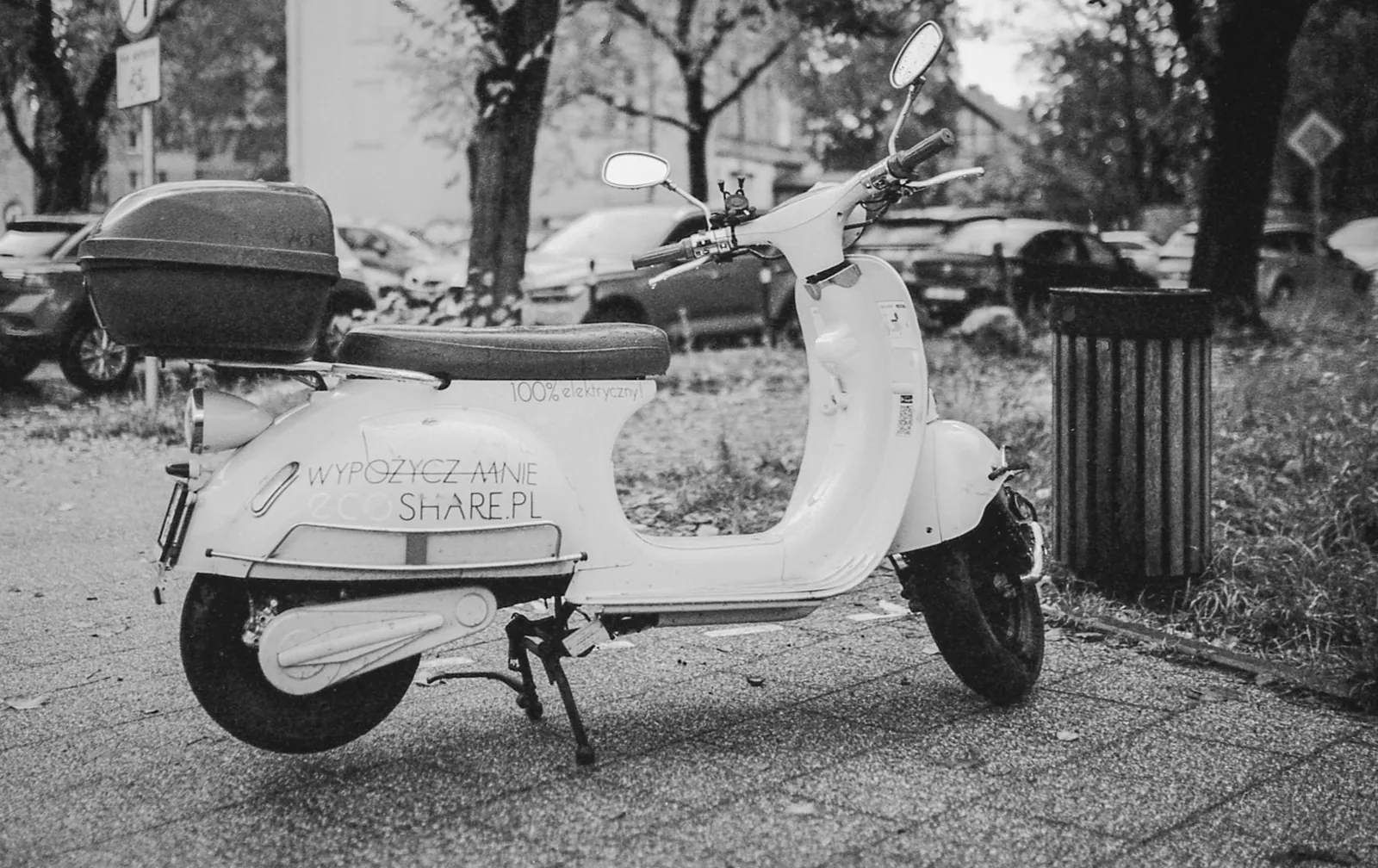 Electric scooter parked on a city sidewalk, available for rental, in a black and white urban scene. Stock photo illustrating Ola Electric Mobility's product launched story.