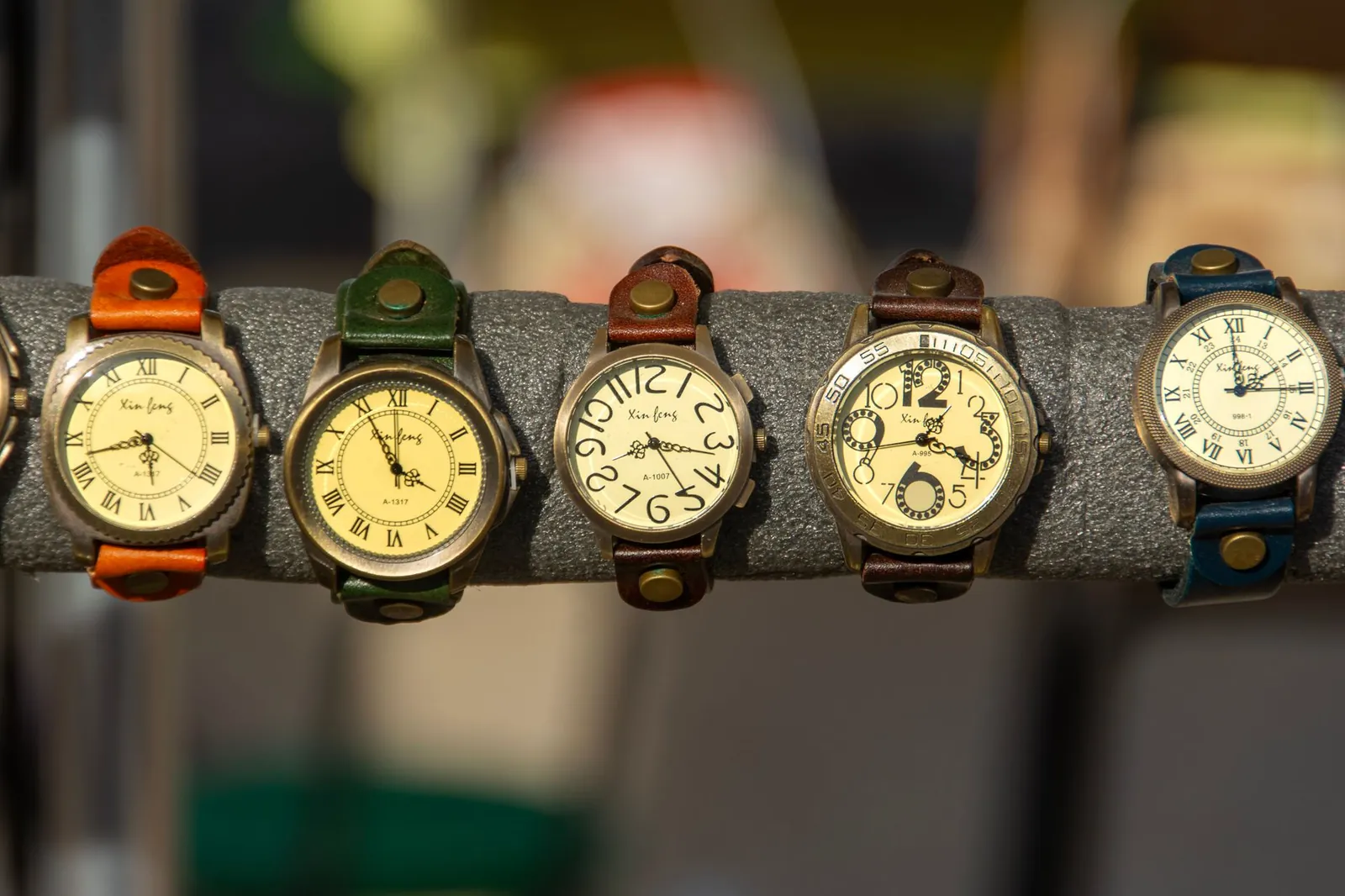 Assorted vintage watches with leather straps on a display rack. Stock photo illustrating Ethos' expansion story.
