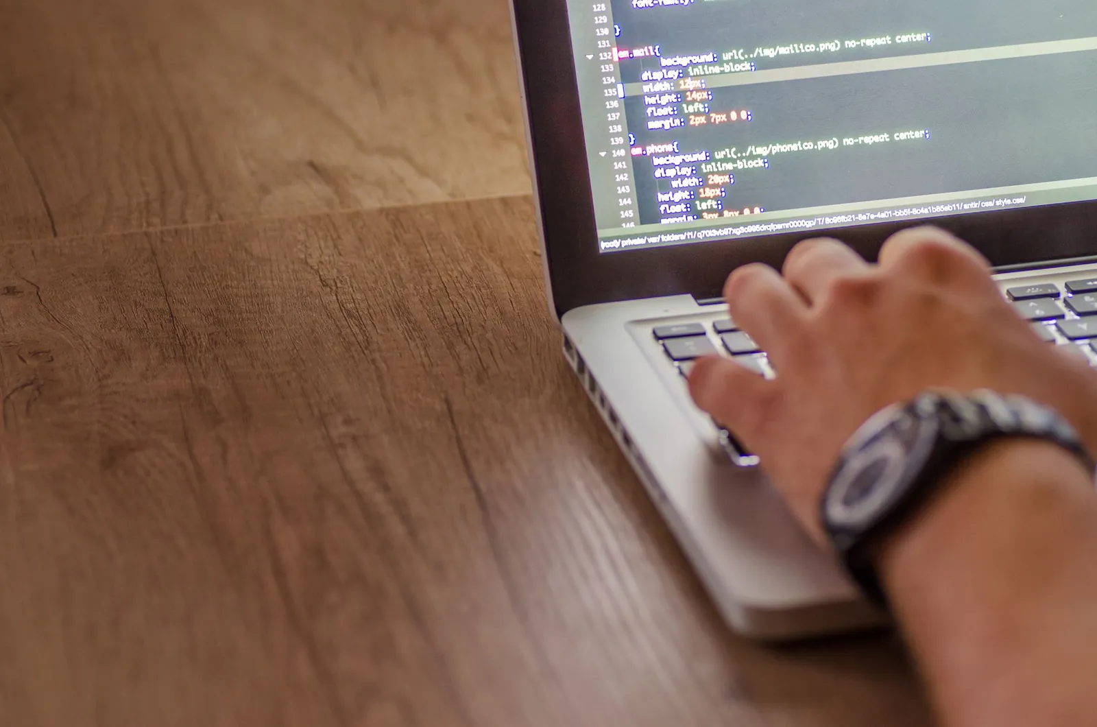 Close-up of a person coding on a laptop, showcasing web development and programming concepts. Stock photo illustrating Optivalue Tek Consulting's new order story.