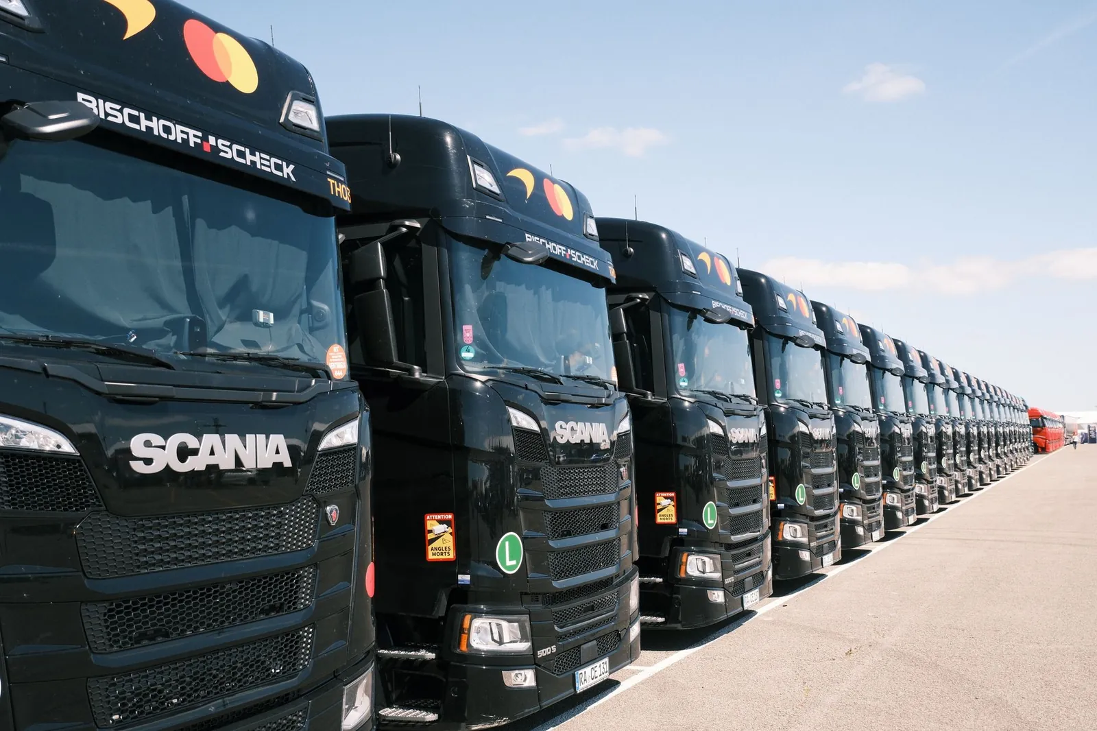 Black Scania trucks lined up outdoors on a sunny day, showcasing transport fleet. Stock photo illustrating Ritco Logistics' new order story.