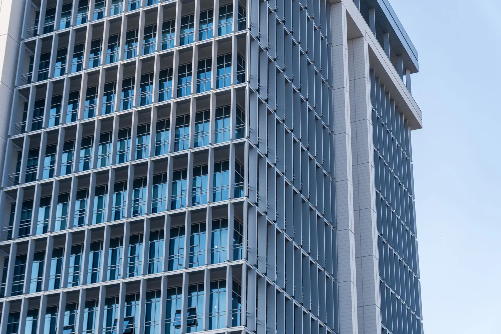 Exploring the sleek design of a modern high-rise office building featuring a glass facade. Stock photo illustrating Capri Global Capital's fund raise story.