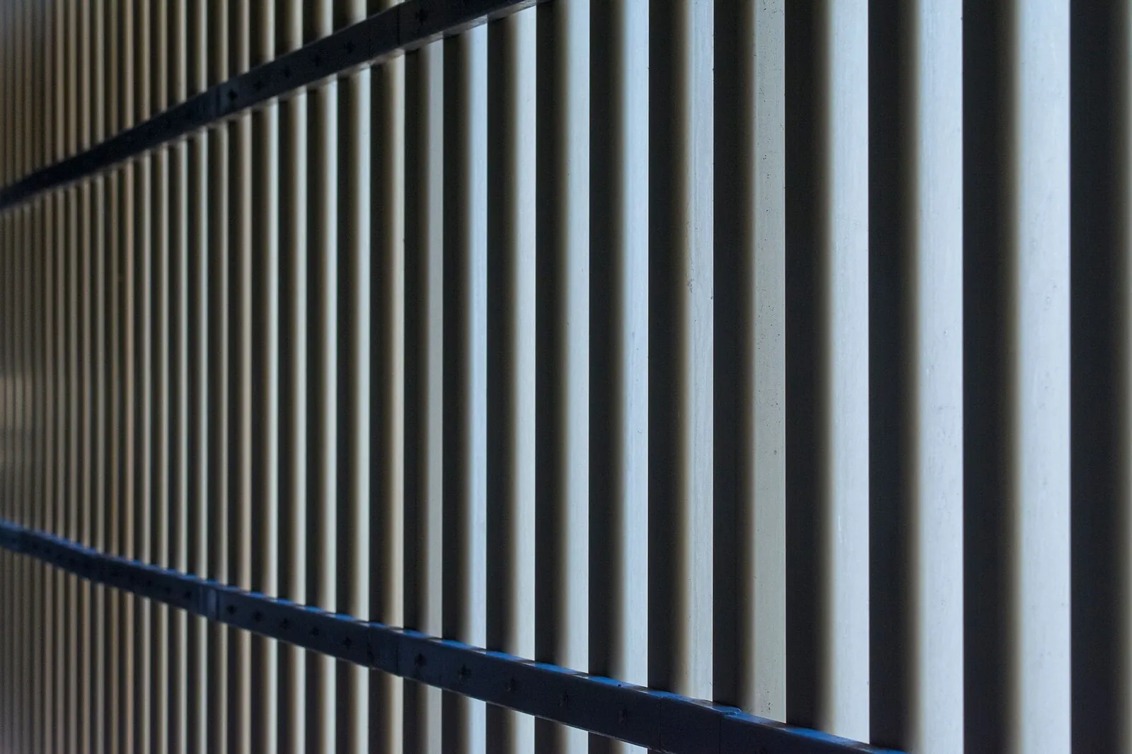 Close-up view of a metallic fence with parallel bars offering a modern industrial feel. Stock photo illustrating Innomet Advanced Materials' new order story.