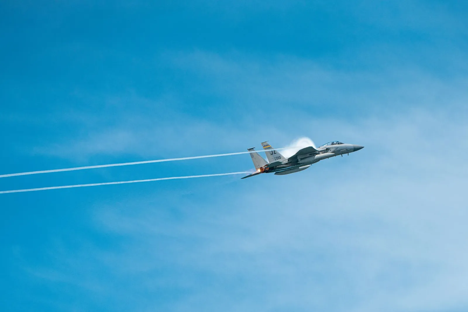 A sleek military jet soaring through a clear blue sky, displaying speed and precision. Stock photo illustrating MTAR Technologies' new order story.