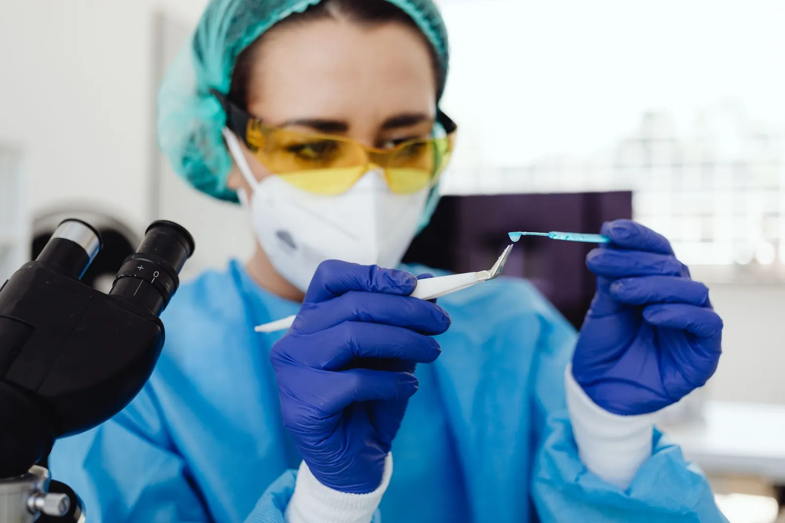Female scientist in protective gear examines sample indoors, utilizing laboratory equipment. Stock photo illustrating UPL's earning call story.