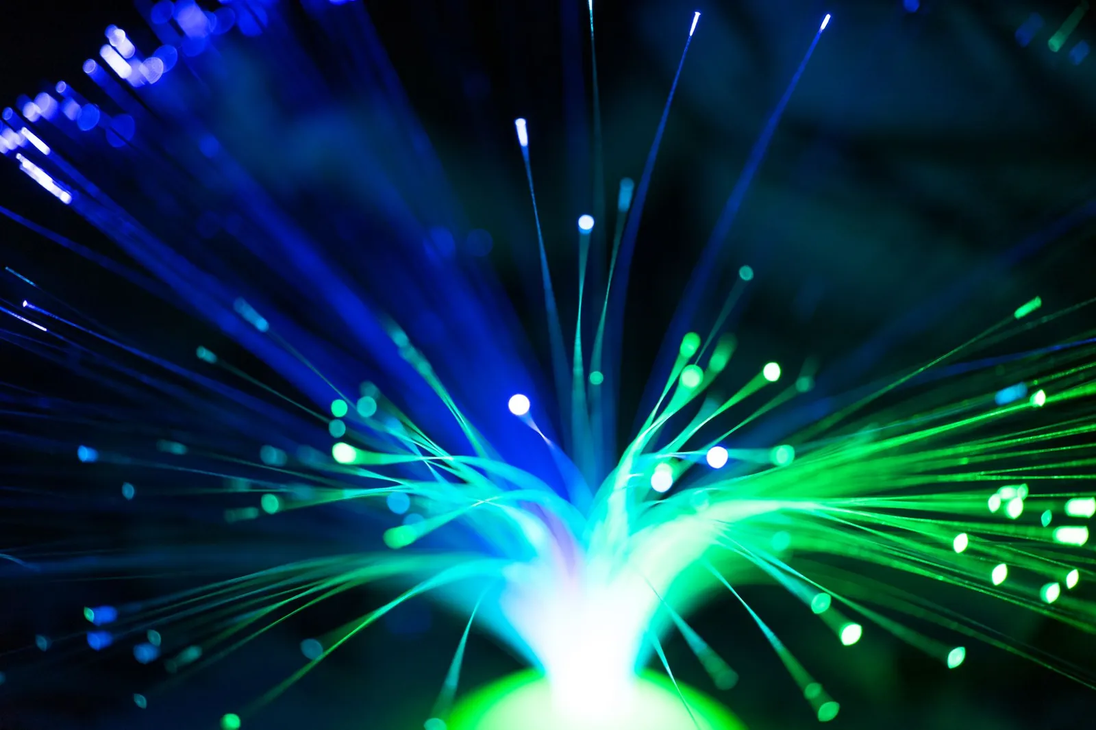 Close-up of illuminated fiber optic lights in blue and green colors, showcasing modern technology. Stock photo illustrating Sterlite Technologies' new order story.