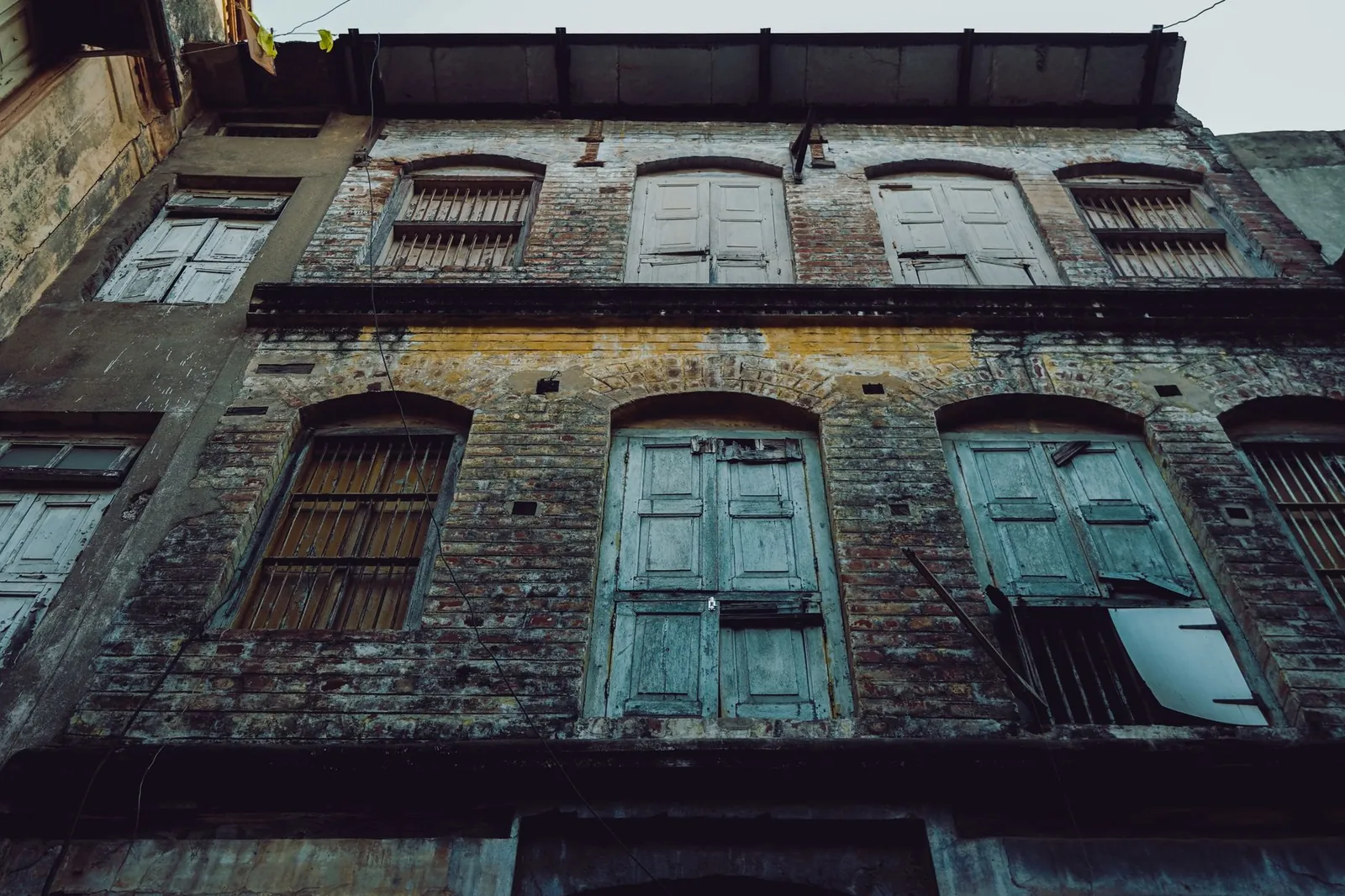 An old and weathered building exterior in Ahmedabad, India, captured from a low angle. Stock photo illustrating CSB Bank's regulatory approval story.