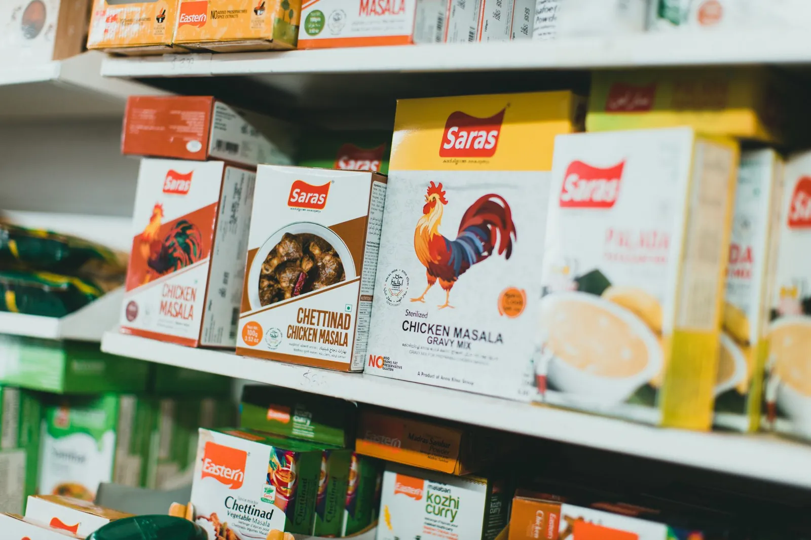 Assortment of Indian spice mixes on a grocery store shelf, featuring colorful packaging. Stock photo illustrating Wardwizard Foods and Beverages' earning call story.