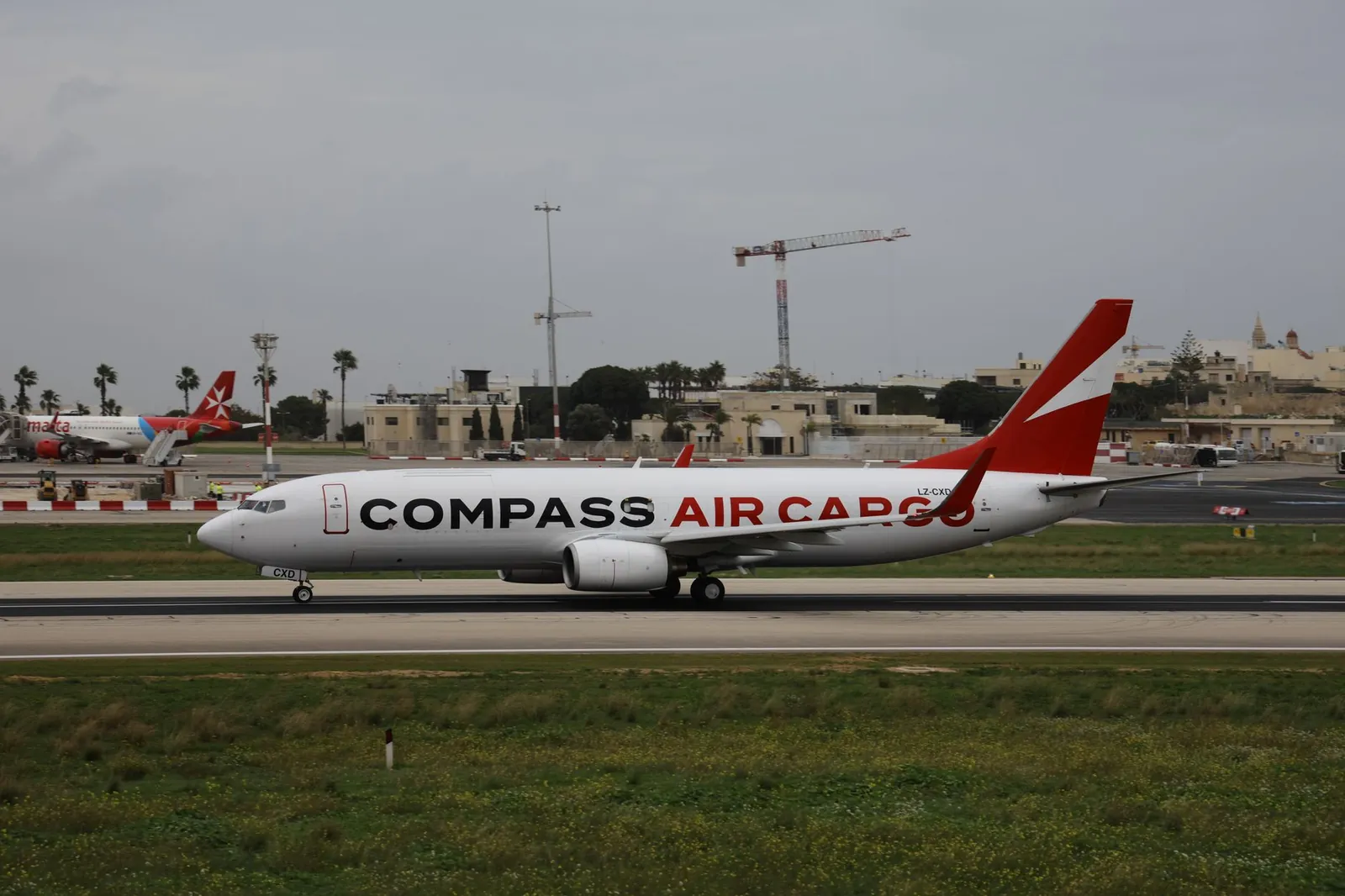 Compass Air Cargo aircraft on runway at airport, ideal for logistics and travel themes. Stock photo illustrating Afcom Holdings' earning call story.