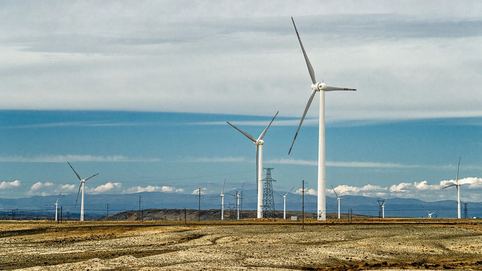 A landscape of numerous wind turbines generating renewable energy on a clear day. Stock photo illustrating KPI Green Energy's new order story.