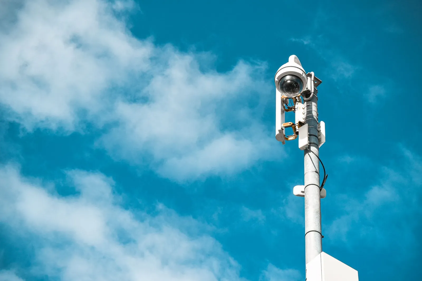 Close-up of a surveillance camera on a pole under a clear blue sky. Stock photo illustrating Magellanic Cloud's fund raise story.