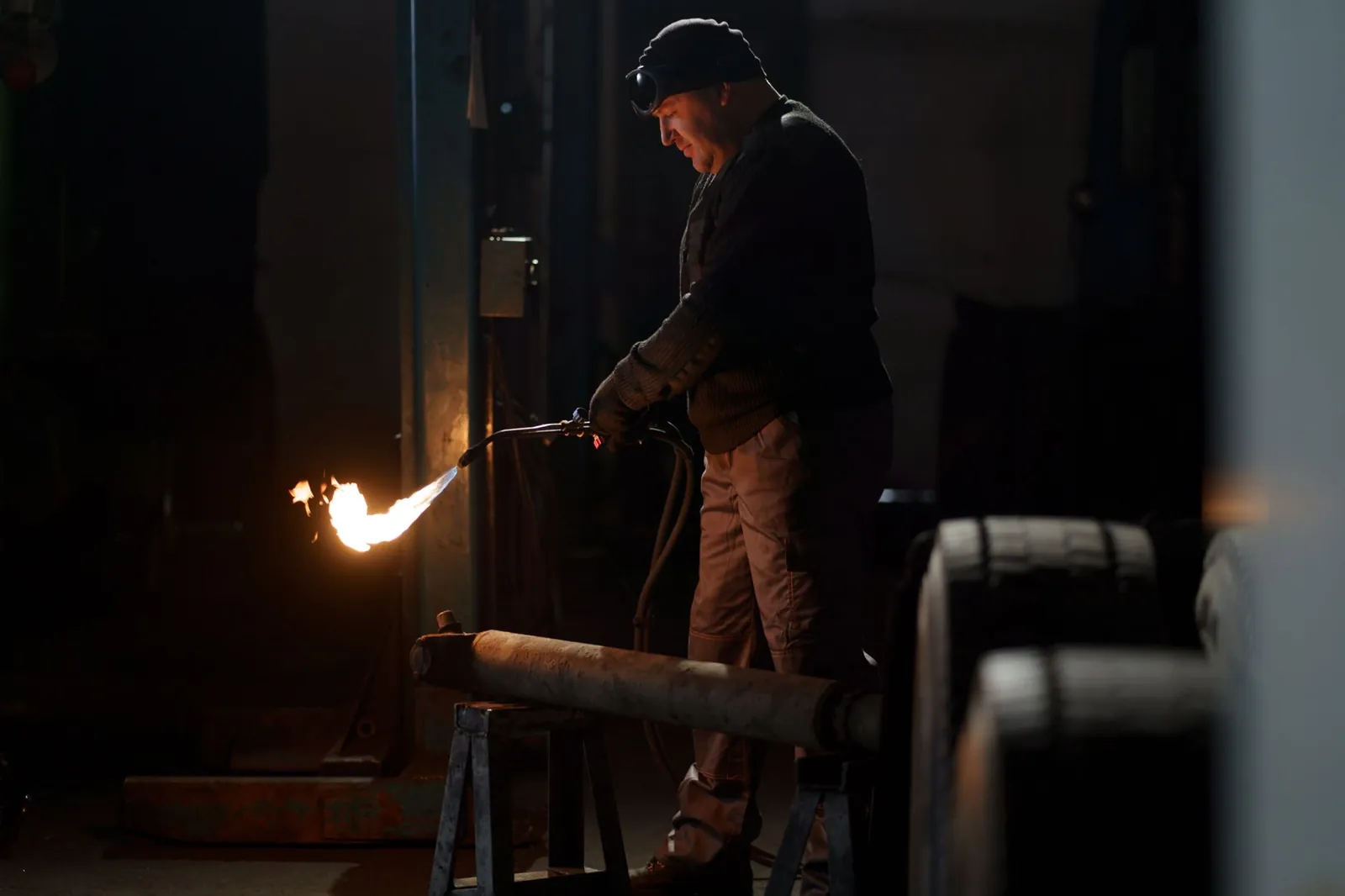 A welder skillfully operates equipment in a dimly lit industrial setting. Stock photo illustrating Likhitha Infrastructure's new order story.