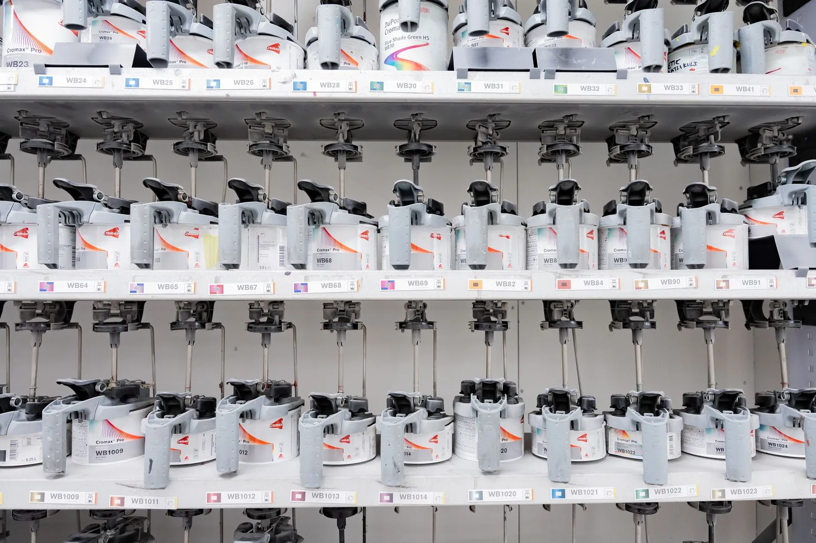 Organized industrial paint mixer station with multiple dispensers for accurate color mixing. Stock photo illustrating Silkflex Polymers (India)'s expansion story.