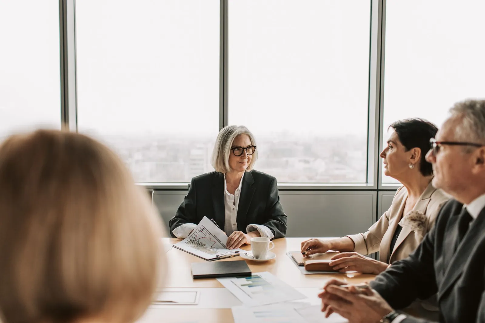 A group of professionals engaged in a business meeting inside a modern office boardroom. Stock photo illustrating MPS's regulatory approval story.