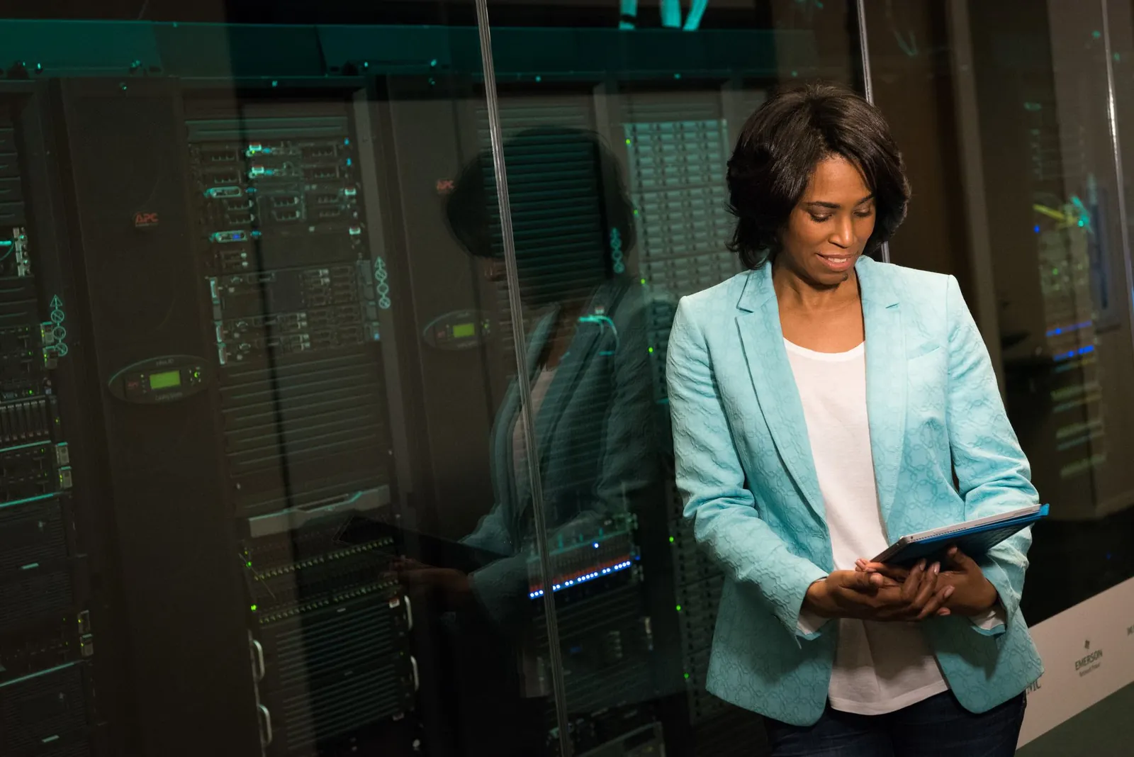Female IT professional examining data servers in a modern data center setting. Stock photo illustrating Black Box's new order story.