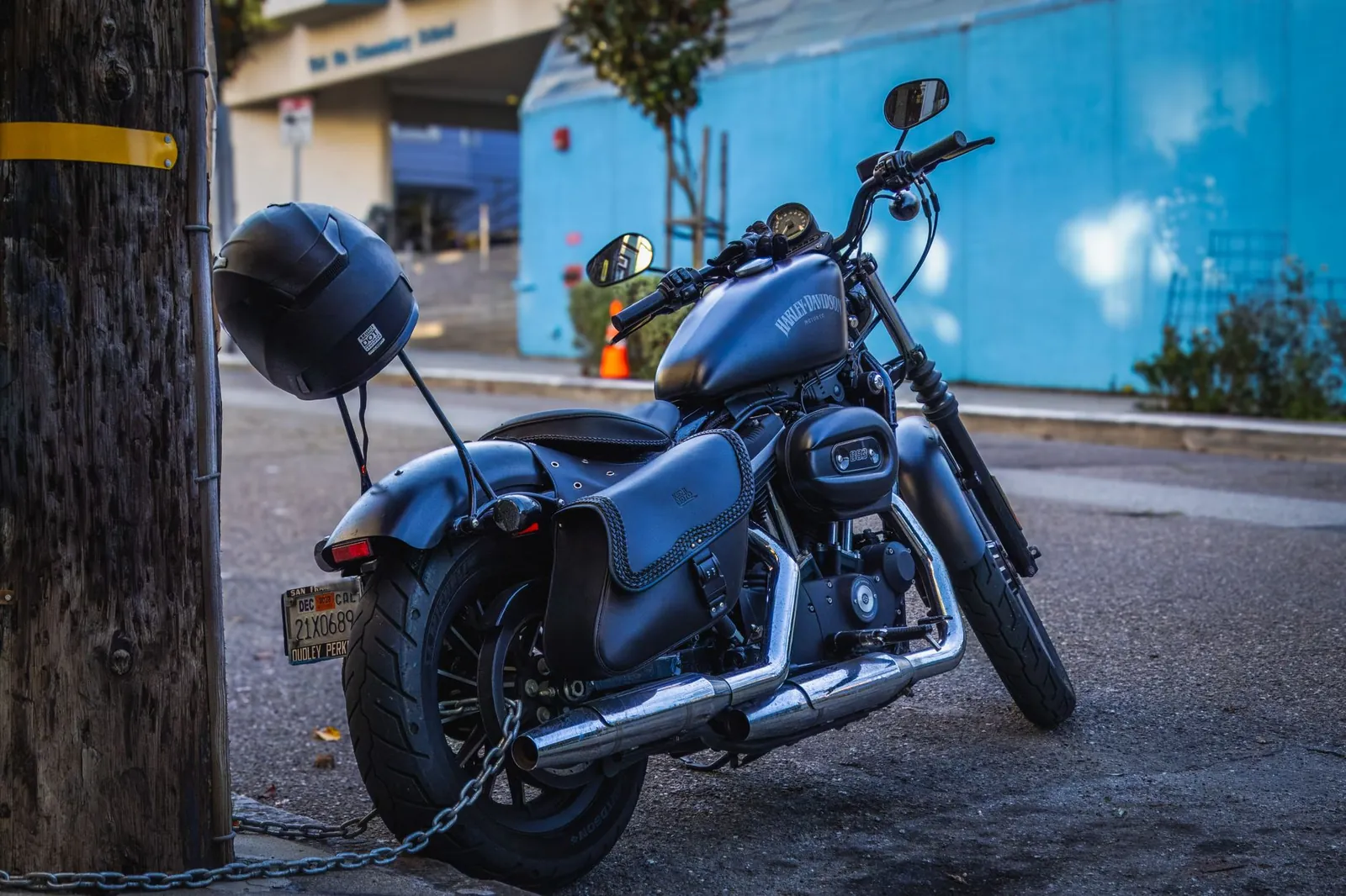 A classic Harley Davidson motorbike chained to a post on a city street, embodying urban lifestyle and adventure. Stock photo illustrating TVS Motor Company's product launched story.