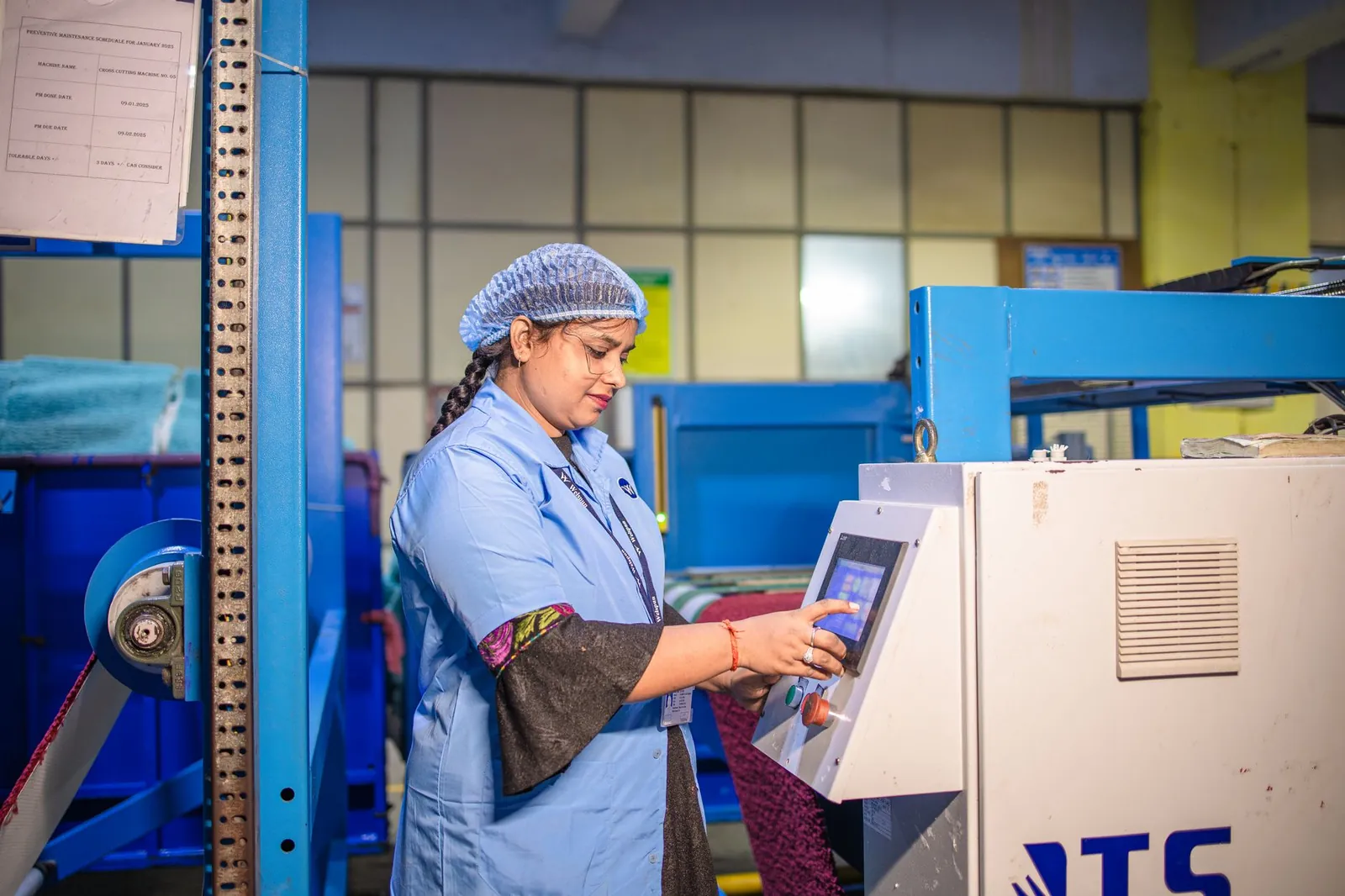 Woman in a textile factory operating machinery, showcasing modern industry. Stock photo illustrating Gujarat Kidney And Super Speciality's expansion story.