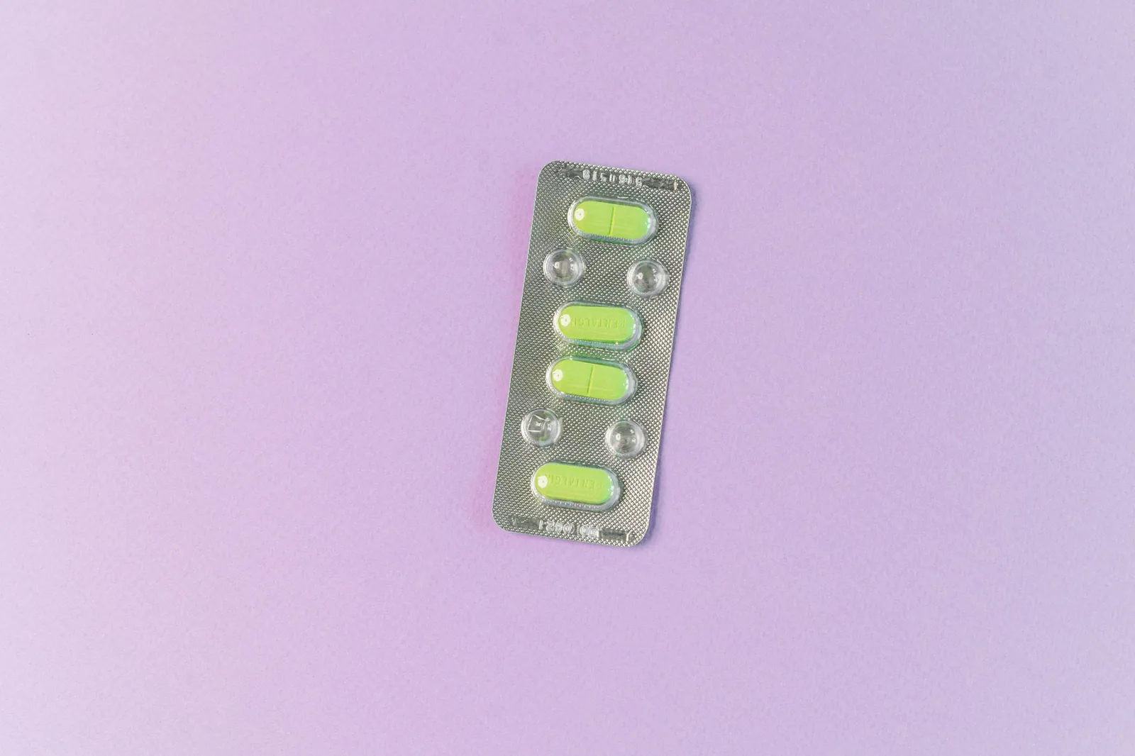 Top view of green tablets in a blister pack on a pastel purple background. Ideal for health and medication themes. Stock photo illustrating RPG Life Sciences' product launched story.