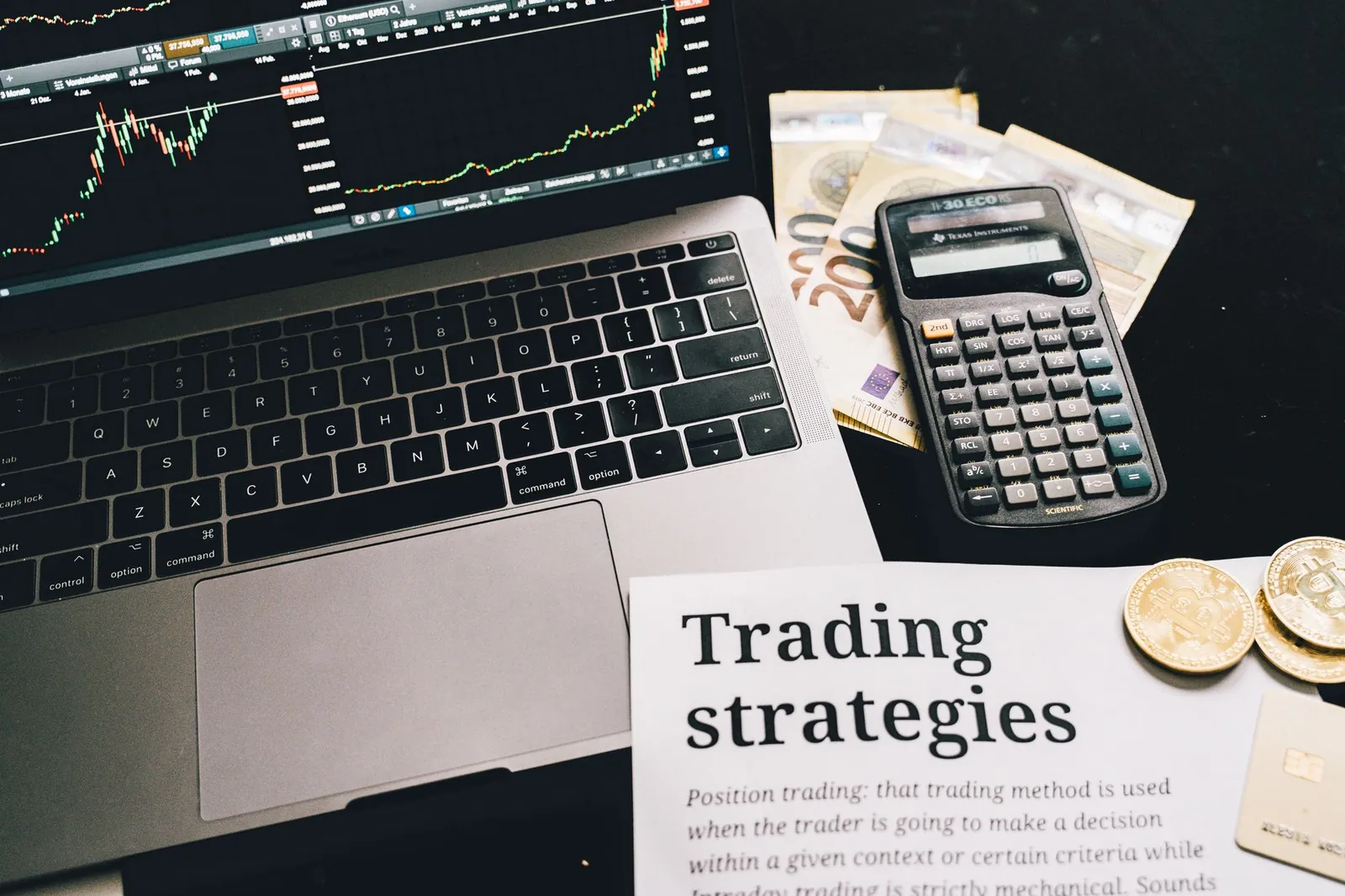 Close-up image of a trading setup with a laptop, calculator, and financial documents, ideal for finance and stock market themes. Stock photo for the ALFA News guide: Insider Trading Penalties in India Under SEBI Rules.