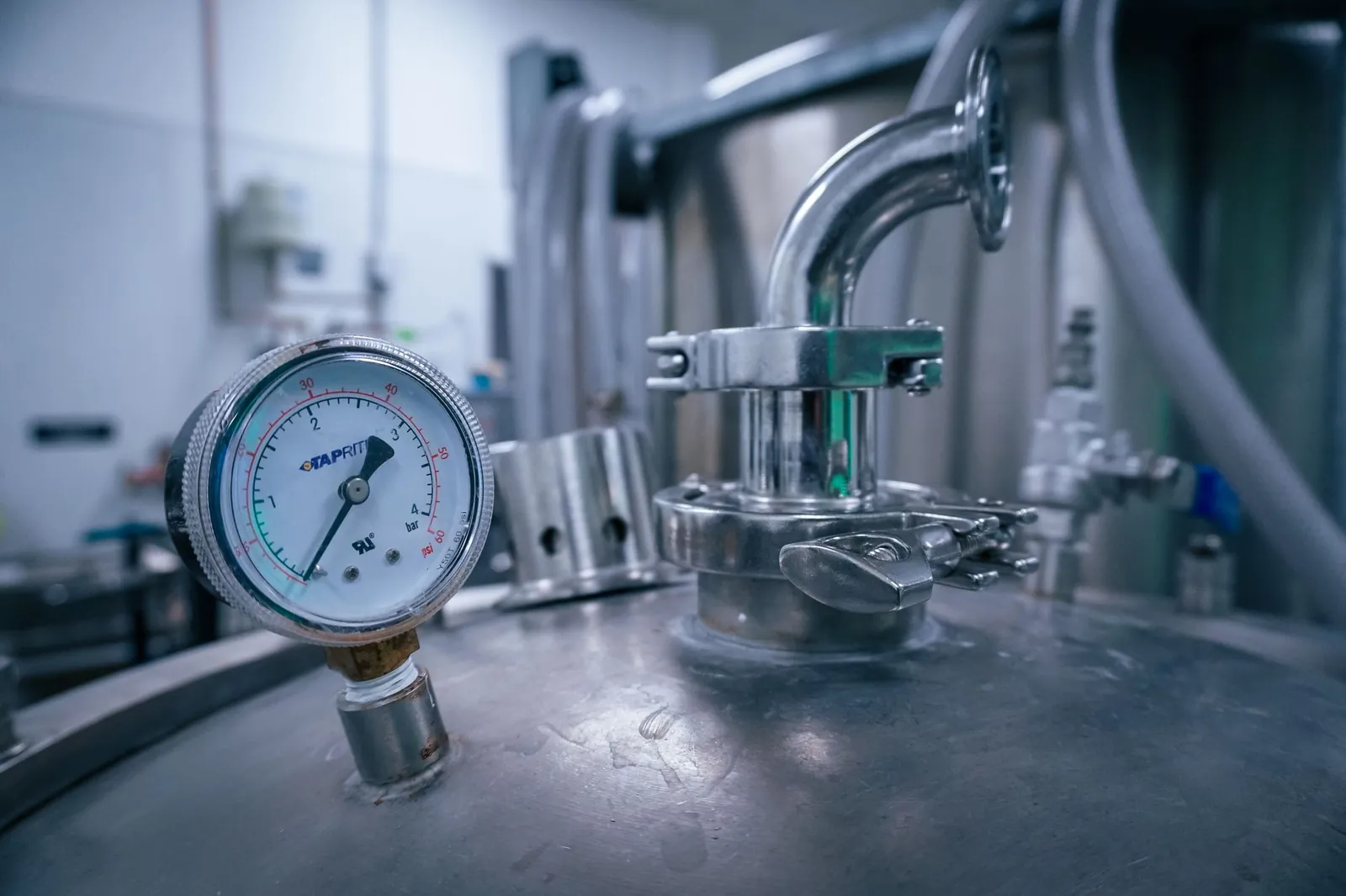 Close-up of a pressure gauge on a stainless steel tank in a sterile industrial setting, showcasing manufacturing technology. Stock photo illustrating Jindal Stainless' partnership story.