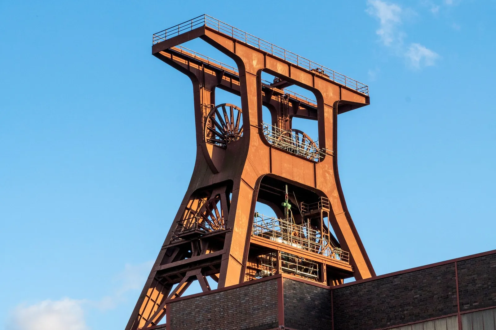 A detailed view of an old rusted industrial mine structure under a clear blue sky, showcasing robust engineering. Stock photo illustrating Steel Exchange India's partnership story.