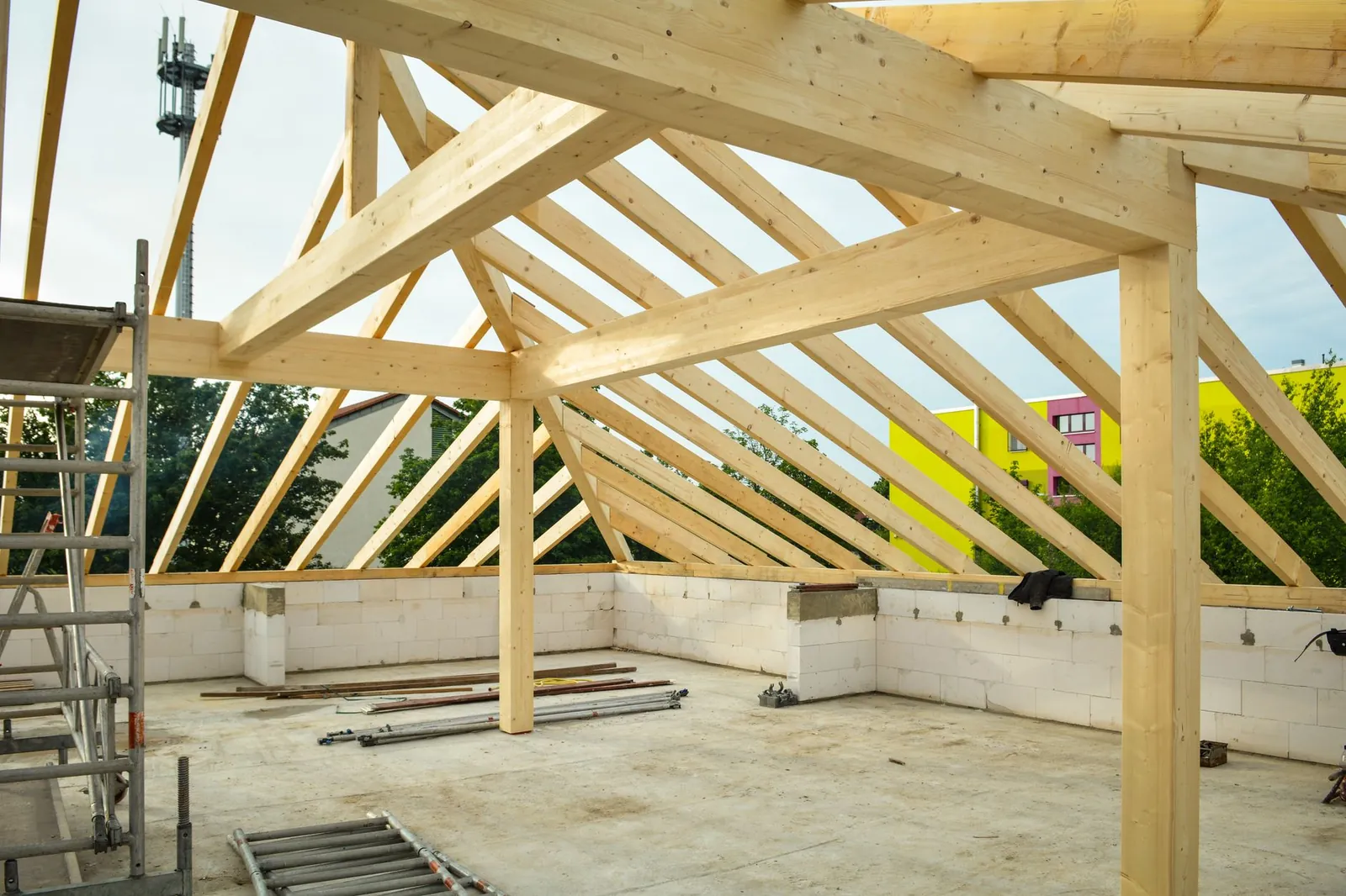 Wooden roof structure in progress with open sky view, ideal for construction themes. Stock photo illustrating Raymond Realty's earning call story.