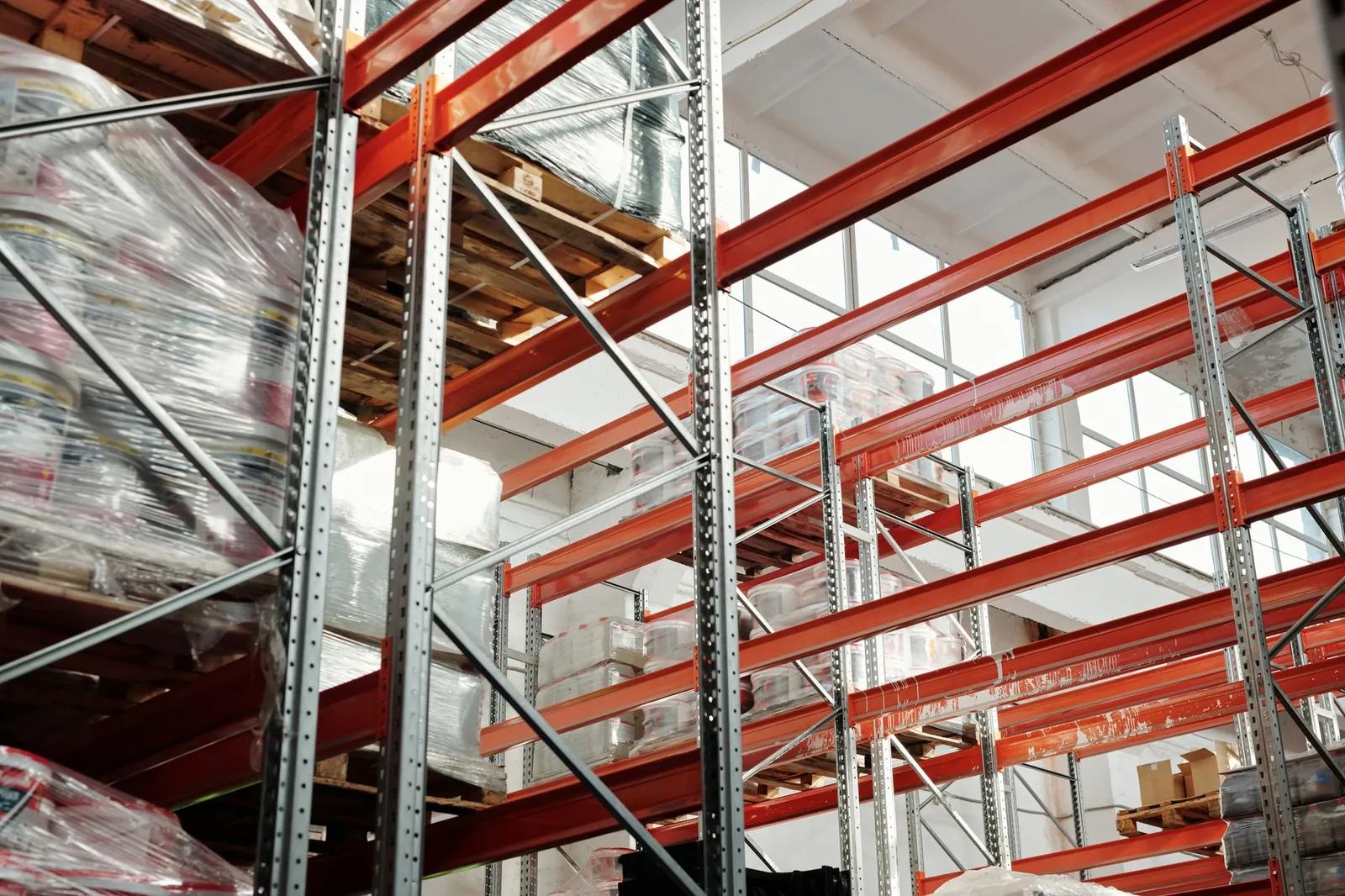 Bright modern warehouse featuring pallets and storage racks for logistics and inventory management. Stock photo illustrating Elitecon International's expansion story.