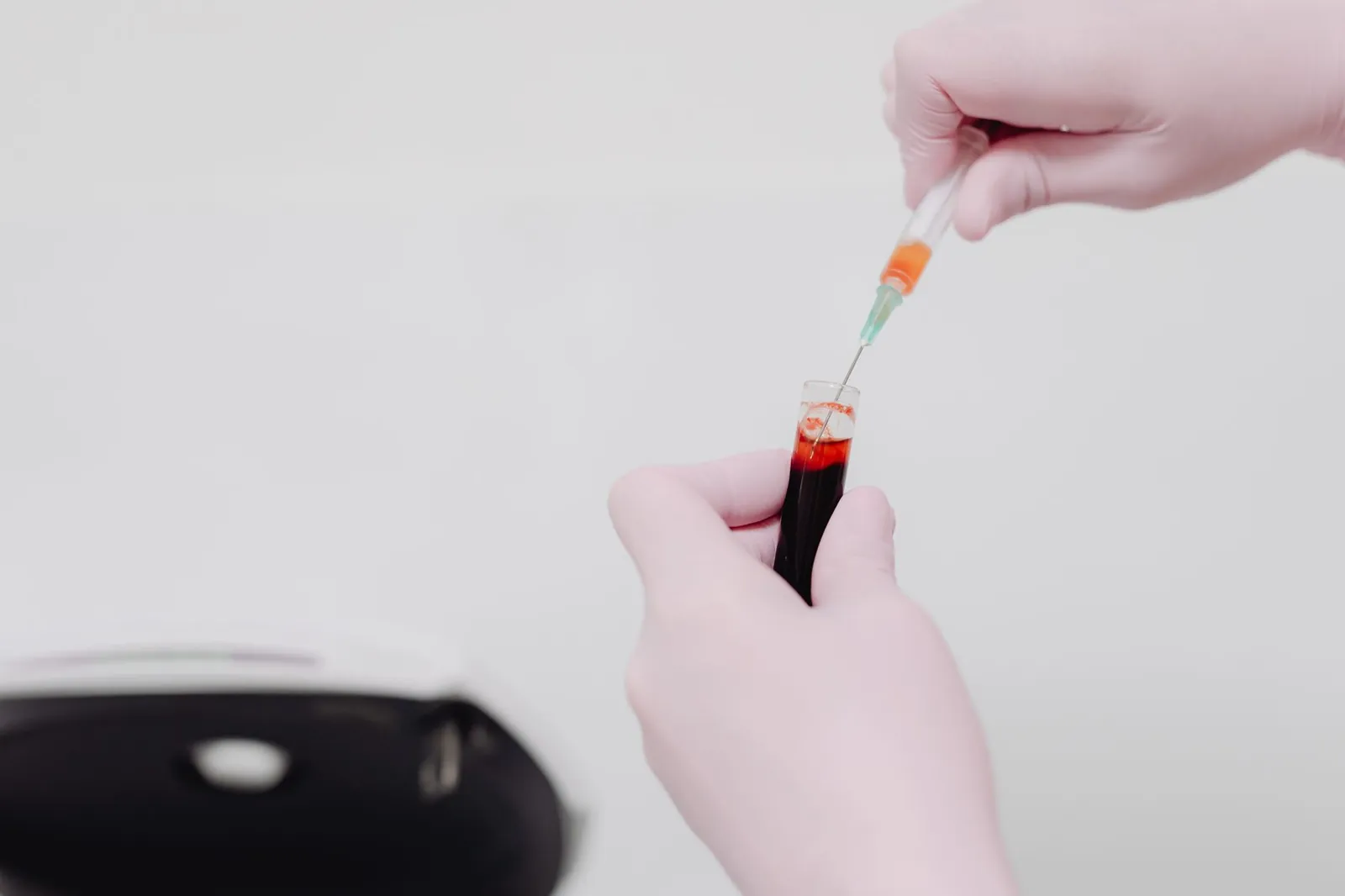 Lab technician using a syringe to handle a blood sample. Medical analysis concept. Stock photo illustrating Lords Mark Industries' expansion story.