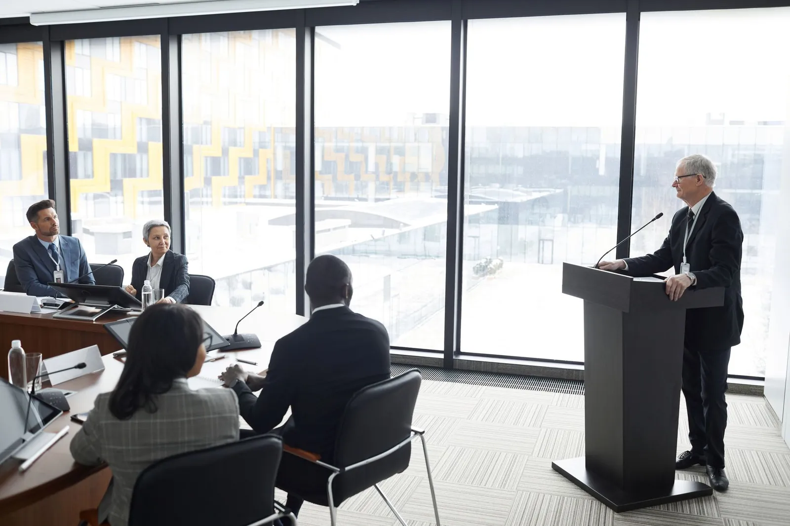 Corporate professionals engaged in a formal business meeting in a modern conference room setting. Stock photo illustrating Apar Industries' fund raise story.