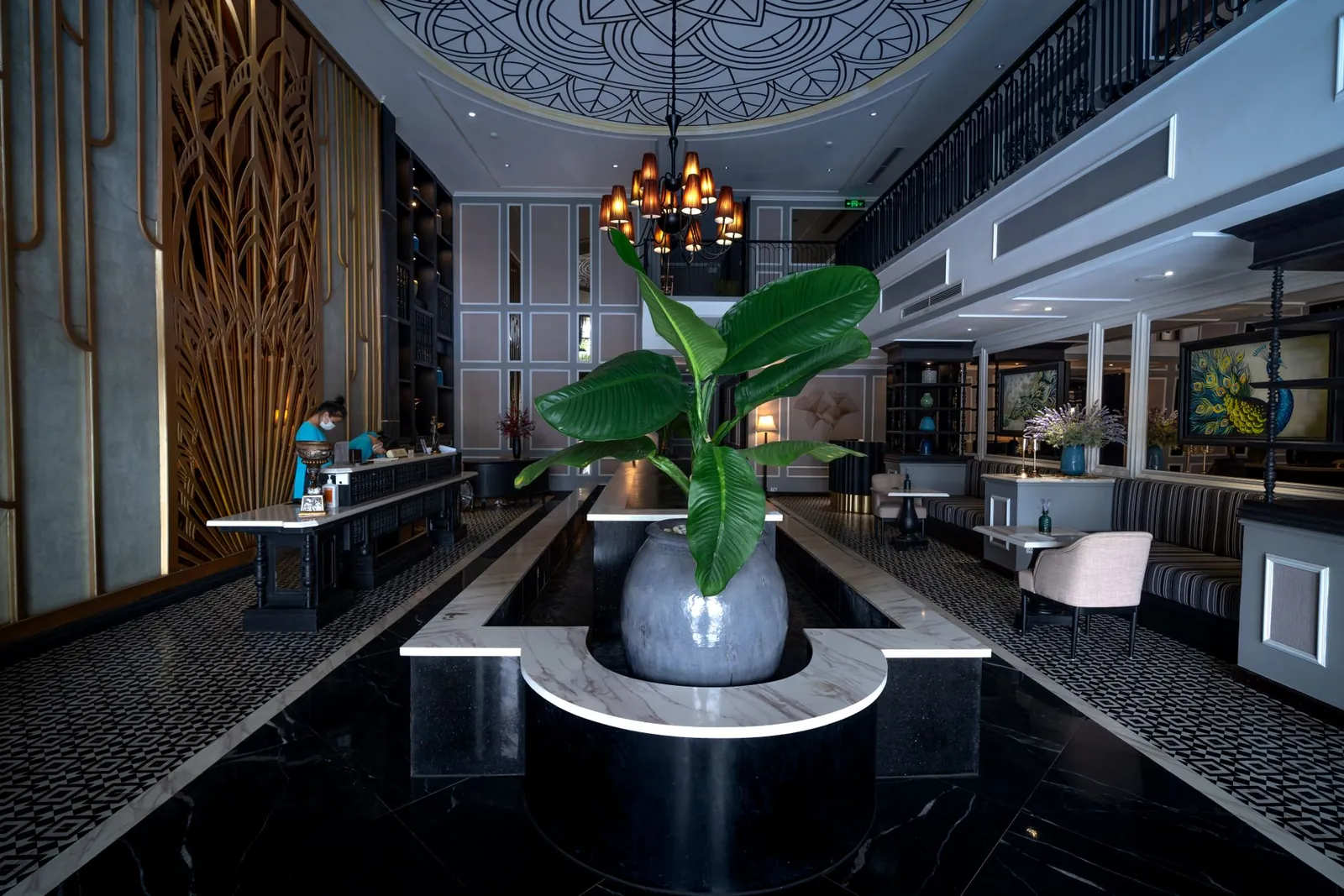 Luxurious hotel lobby featuring sleek decor, stylish chandelier, and central plant arrangement. Stock photo illustrating Samhi Hotels' earning call story.