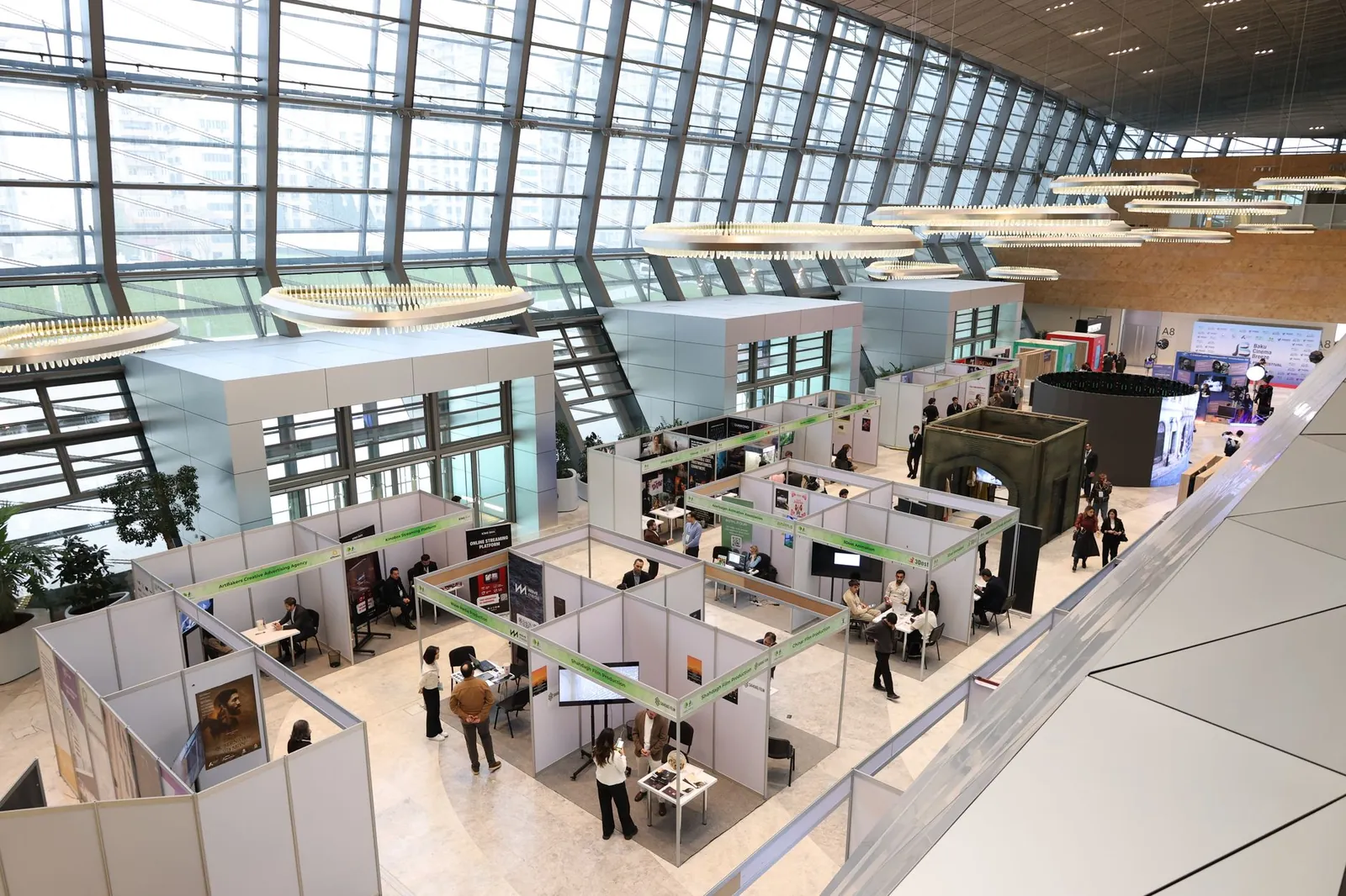 A bustling trade show exhibition inside a modern hall with people networking and exploring booths. Stock photo illustrating Exhicon Events Media Solutions' product launched story.