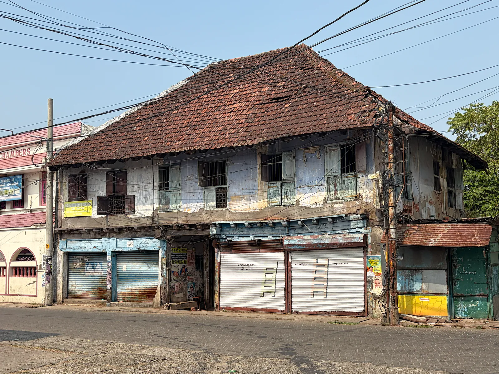An aged colonial building with rusted shutters in Kochi, Kerala, India, showing rustic charm. Stock photo illustrating Punjab & Sind Bank's earning call story.